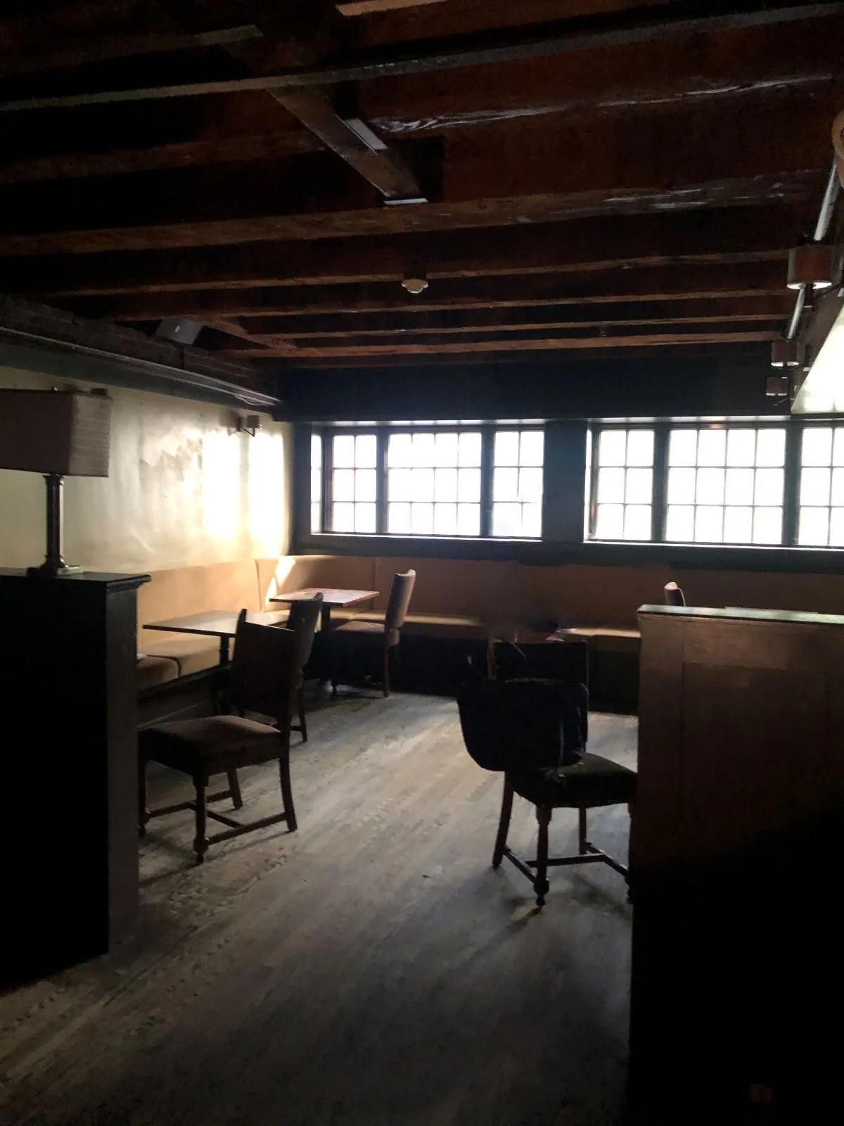 Dark, compartmentalized interior of a 225-year-old building before a commercial fit-out, featuring original low-clearance timber ceilings and masonry walls.