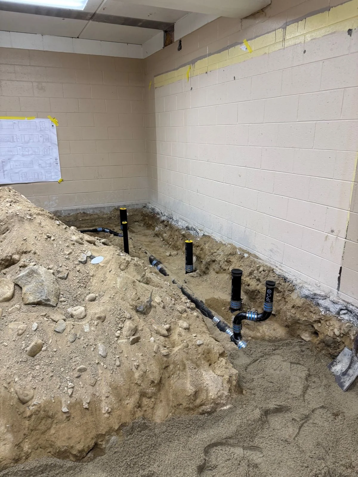 Plumbing rough-in prior to new slab pour for new plumbing fixture placement in reconfigured locker rooms