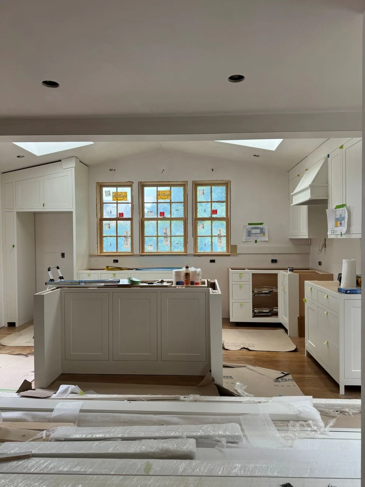 White inset painted cabinetry installation phase in a Dutch colonial Medford, MA kitchen addition