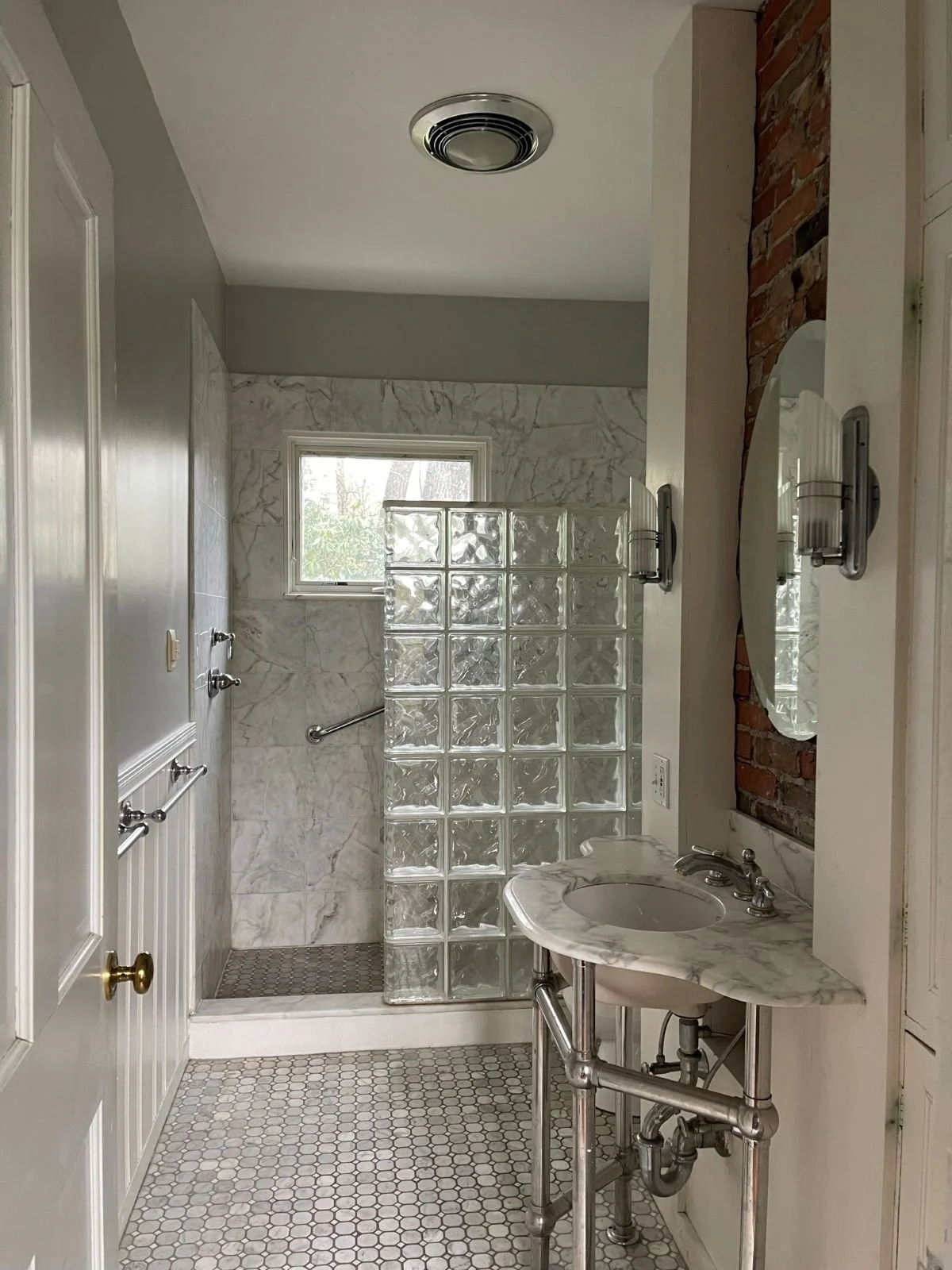 Existing guest bathroom of an 1846 Victorian home in Newton MA prior to reconfiguration showing glass block shower enclosure, exposed chimney and original tile