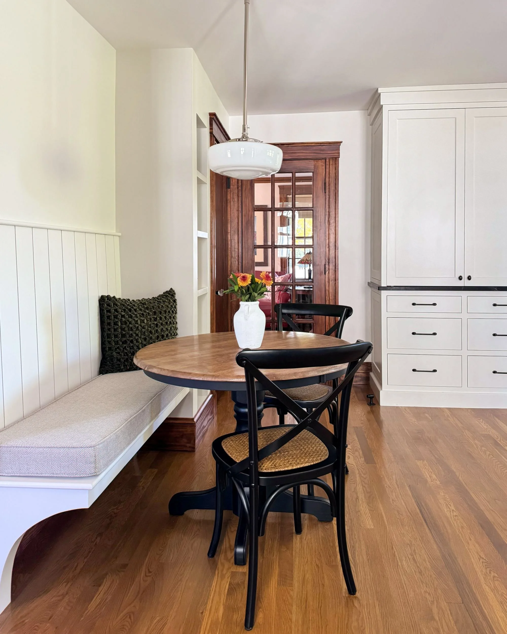 Breakfast nook with built-in bench seating, round pedestal table, and stained woodwork, Medford MA kitchen addition