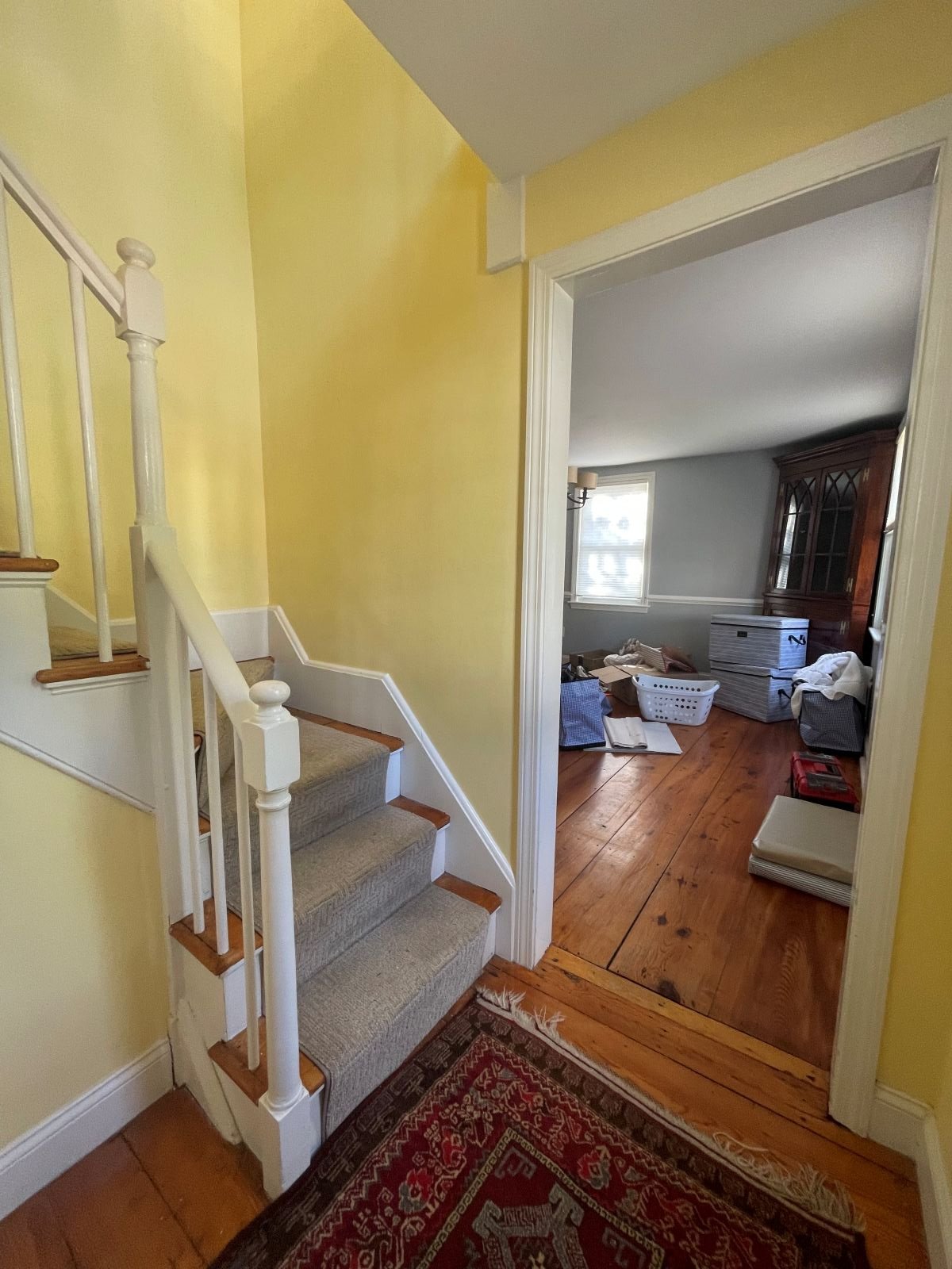 A compartmentalized entry foyer with original staircase in Bedford colonial before renovation.