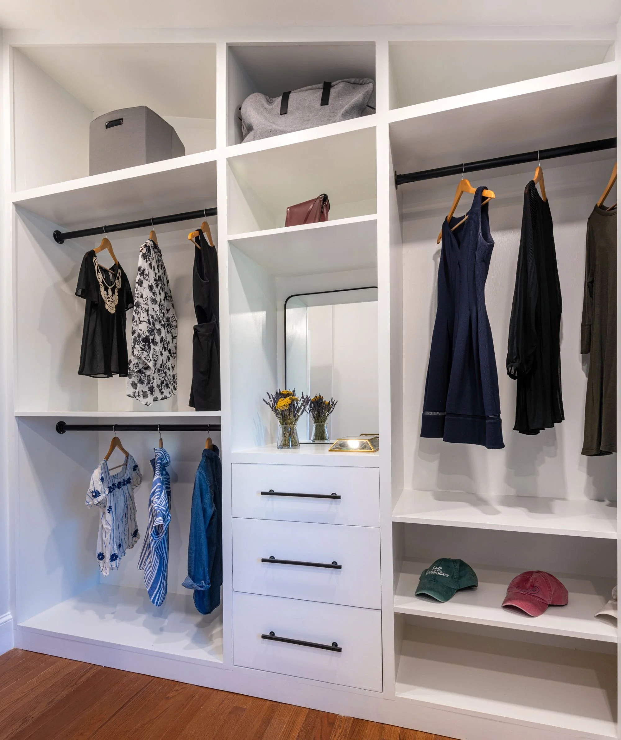 custom white closet built-ins with hanging and drawers in a primary suite in Medford, MA