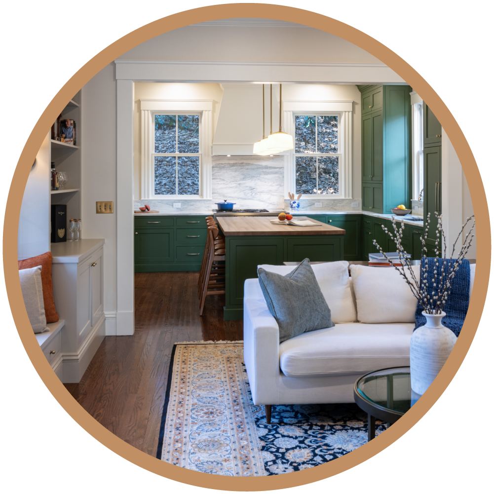 The completed open-concept kitchen featuring custom green cabinetry, marble surfaces, and a seamless transition to the living area.