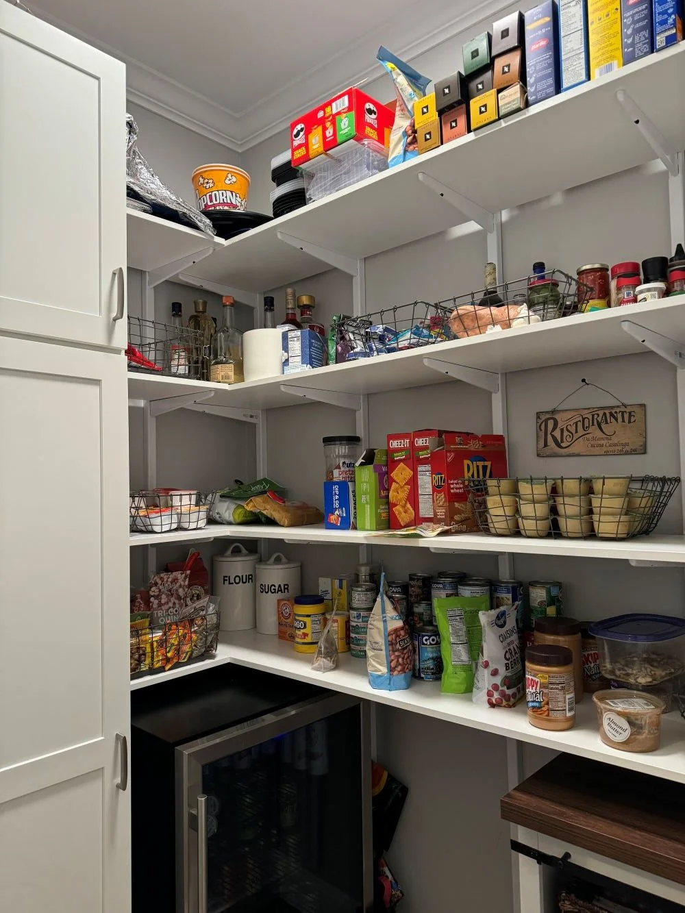 Existing standard pantry with white adjustable shelving and one white tall cabinet.