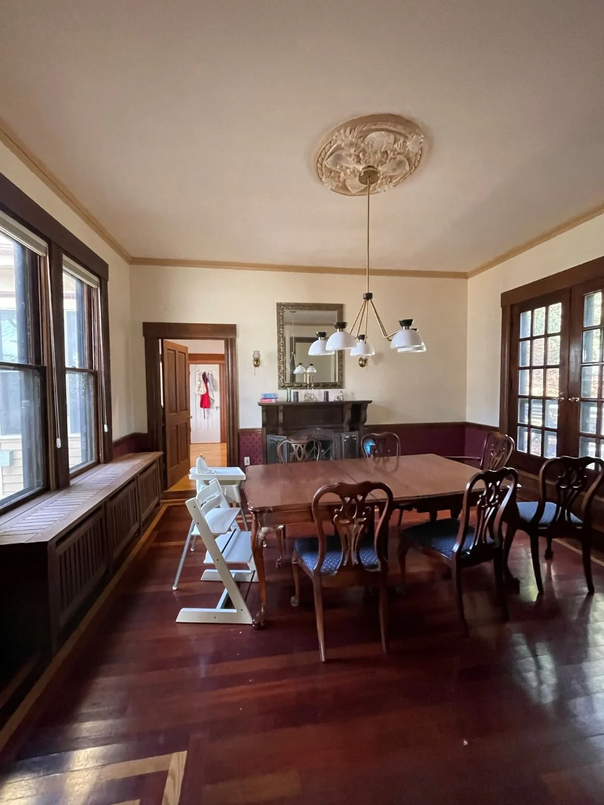  Existing dining room of an 1846 Victorian home in Newton MA prior to renovation showing original millwork, period chandelier and dark hardwood floors before reconfiguration IMG_9666