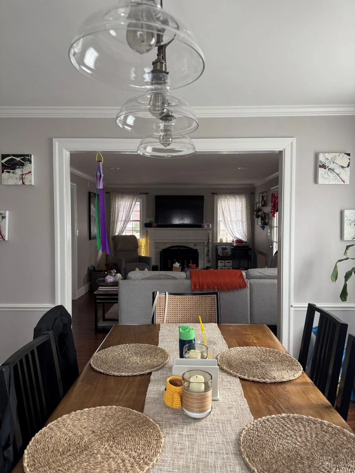 Living room with fireplace and mounted TV next to a dining table
