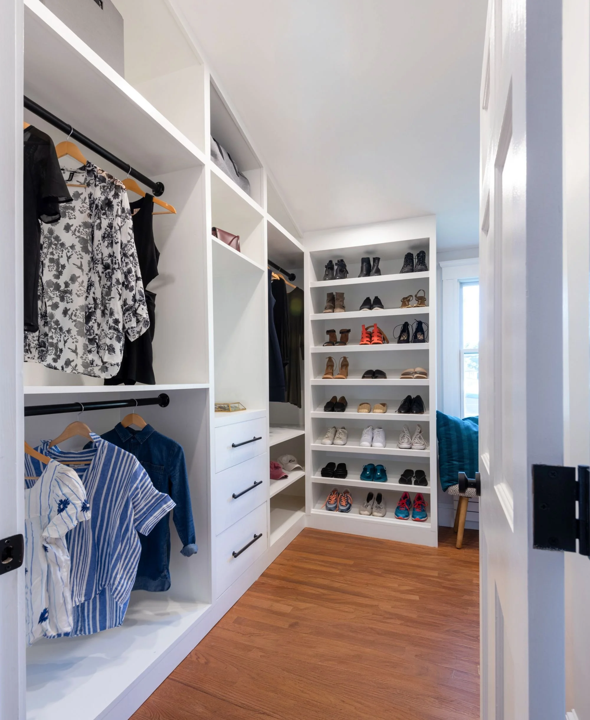 entry view of walk-in-closet with custom built-ins in vaulted room in Medford, MA primary suite