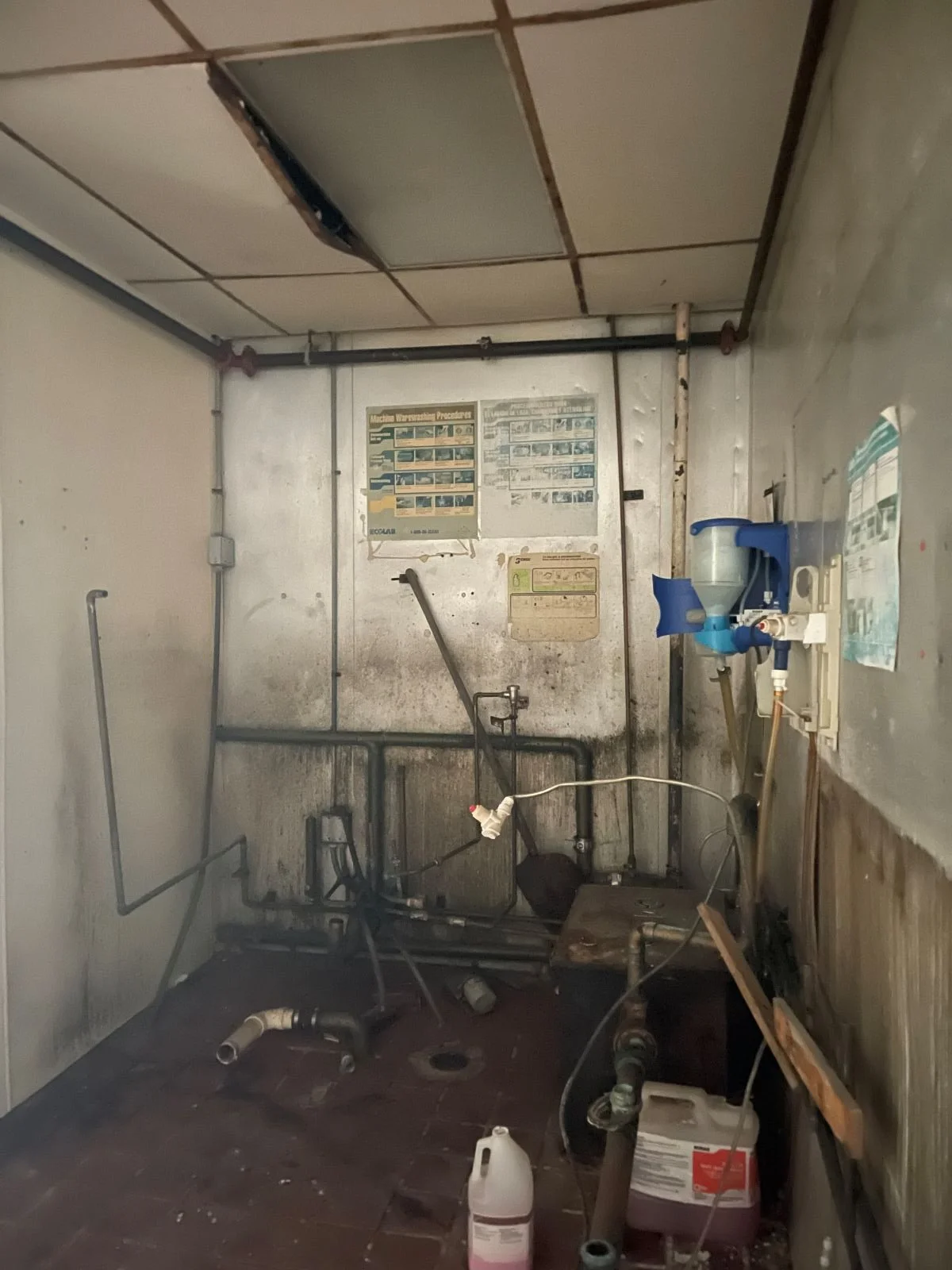 Deteriorated walls and exposed plumbing in an abandoned commercial kitchen in downtown Boston.
