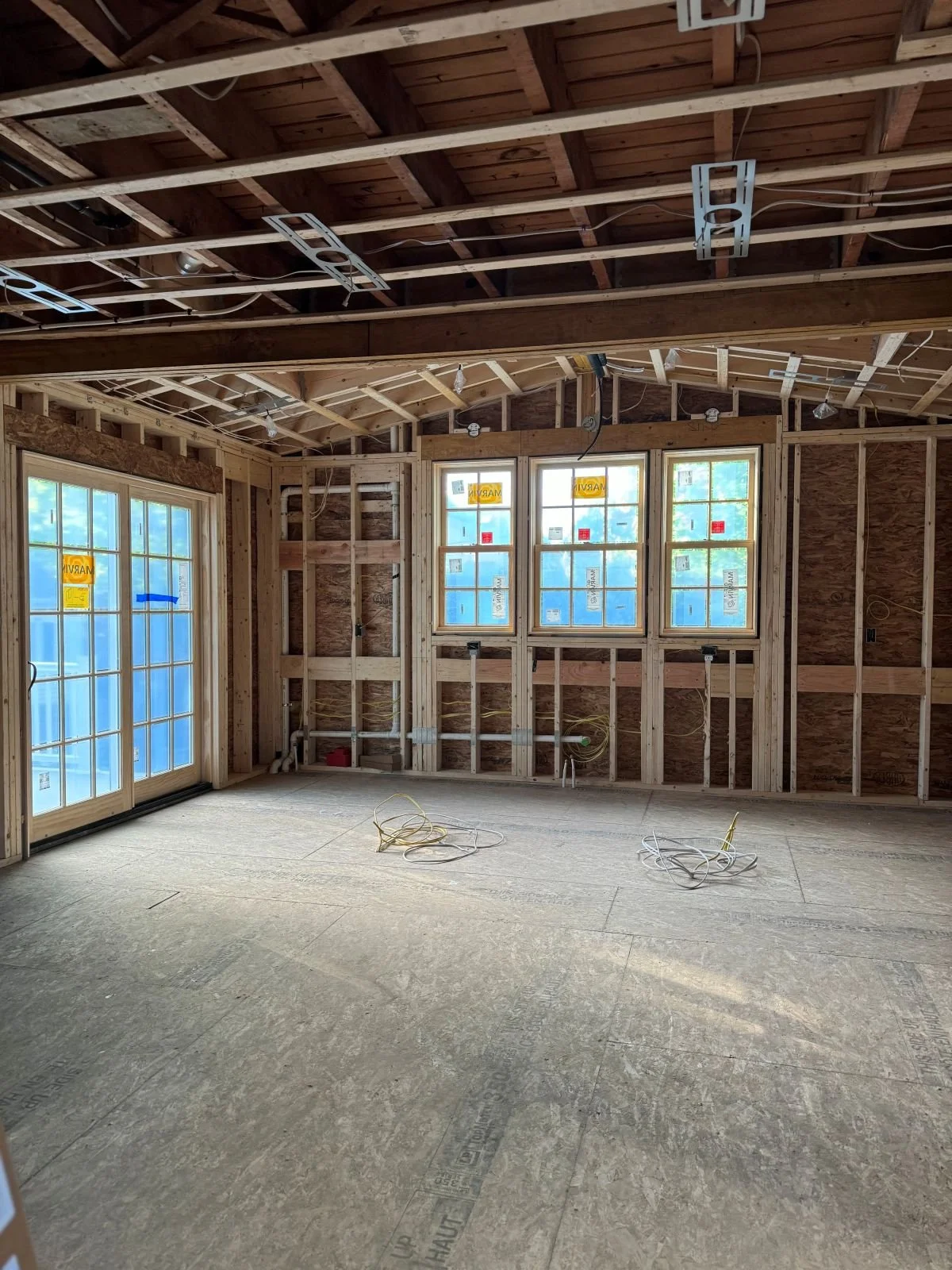 Rough framing and systems complete with Marvin windows and doors installed in a Dutch colonial Medford, MA addition