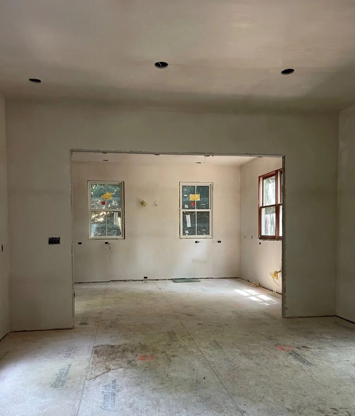 New interior walls following board and plaster installation, defining the reimagined spatial volume of the home.