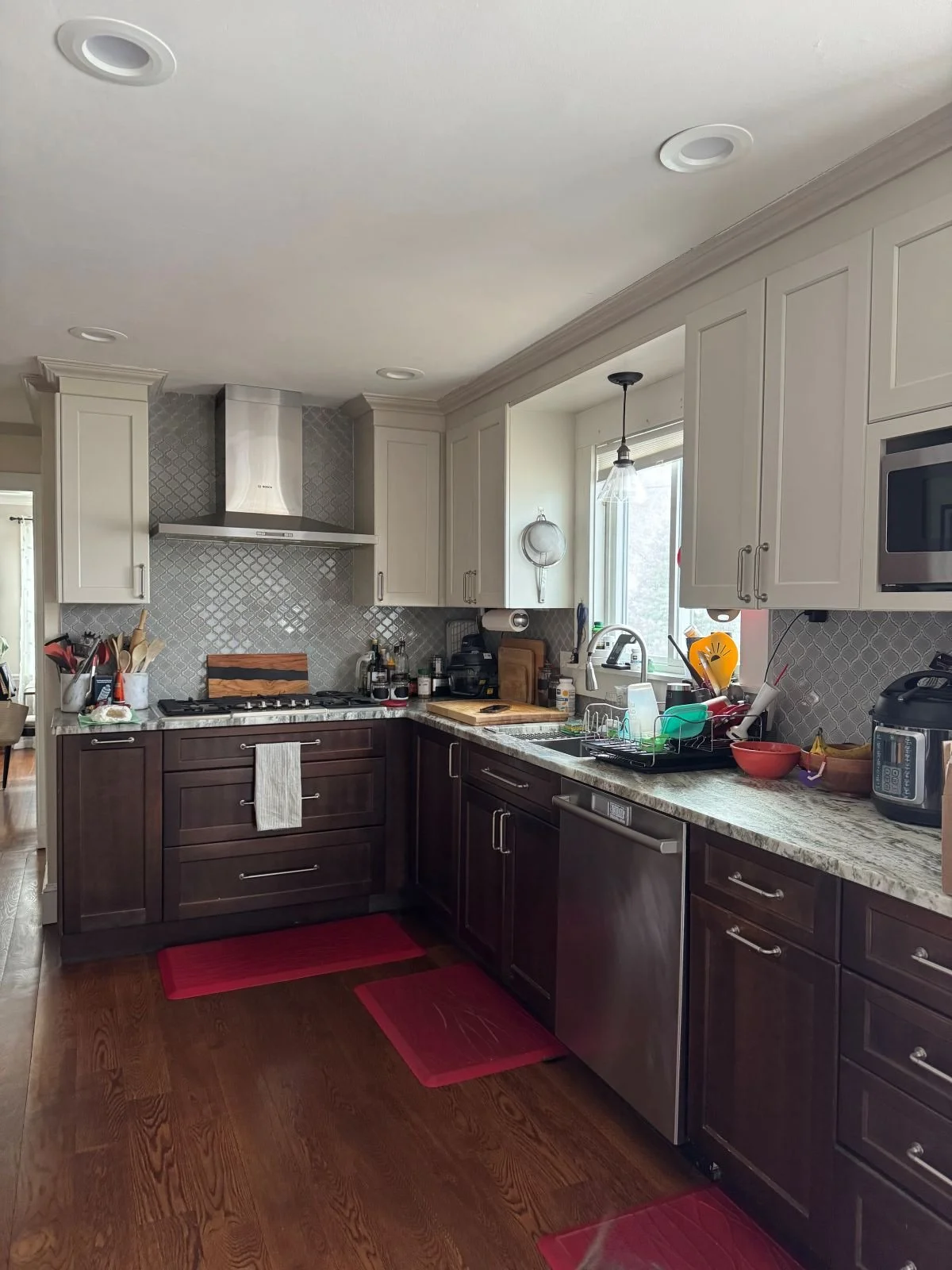 Existing kitchen with dark wood cabinetry and patterned floor mats