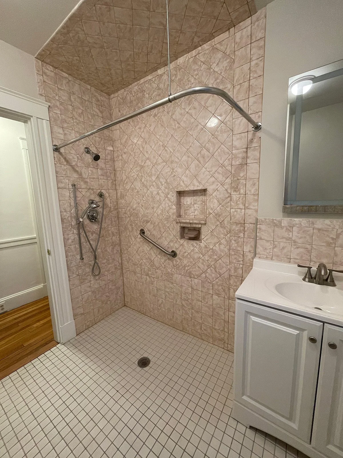ADA roll in shower with pink wall tile prior to remodel