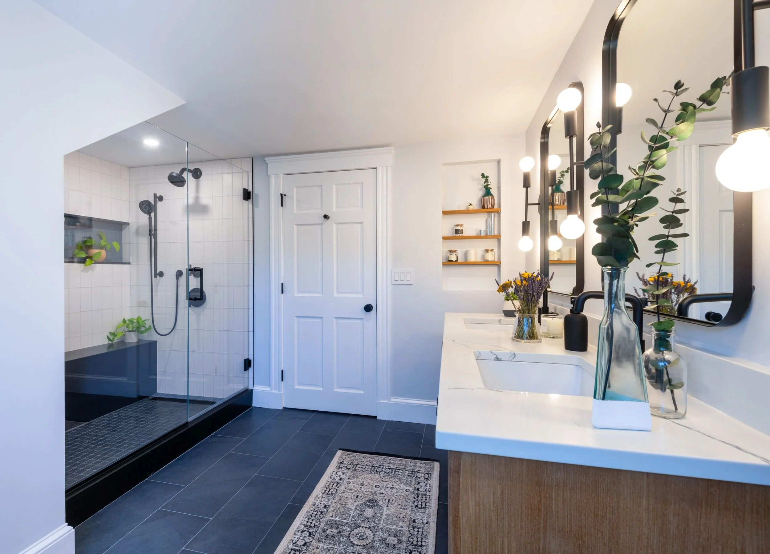 overview of vanity and shower in modern primary bathroom with black, slate blue and white tile in Medford, MA