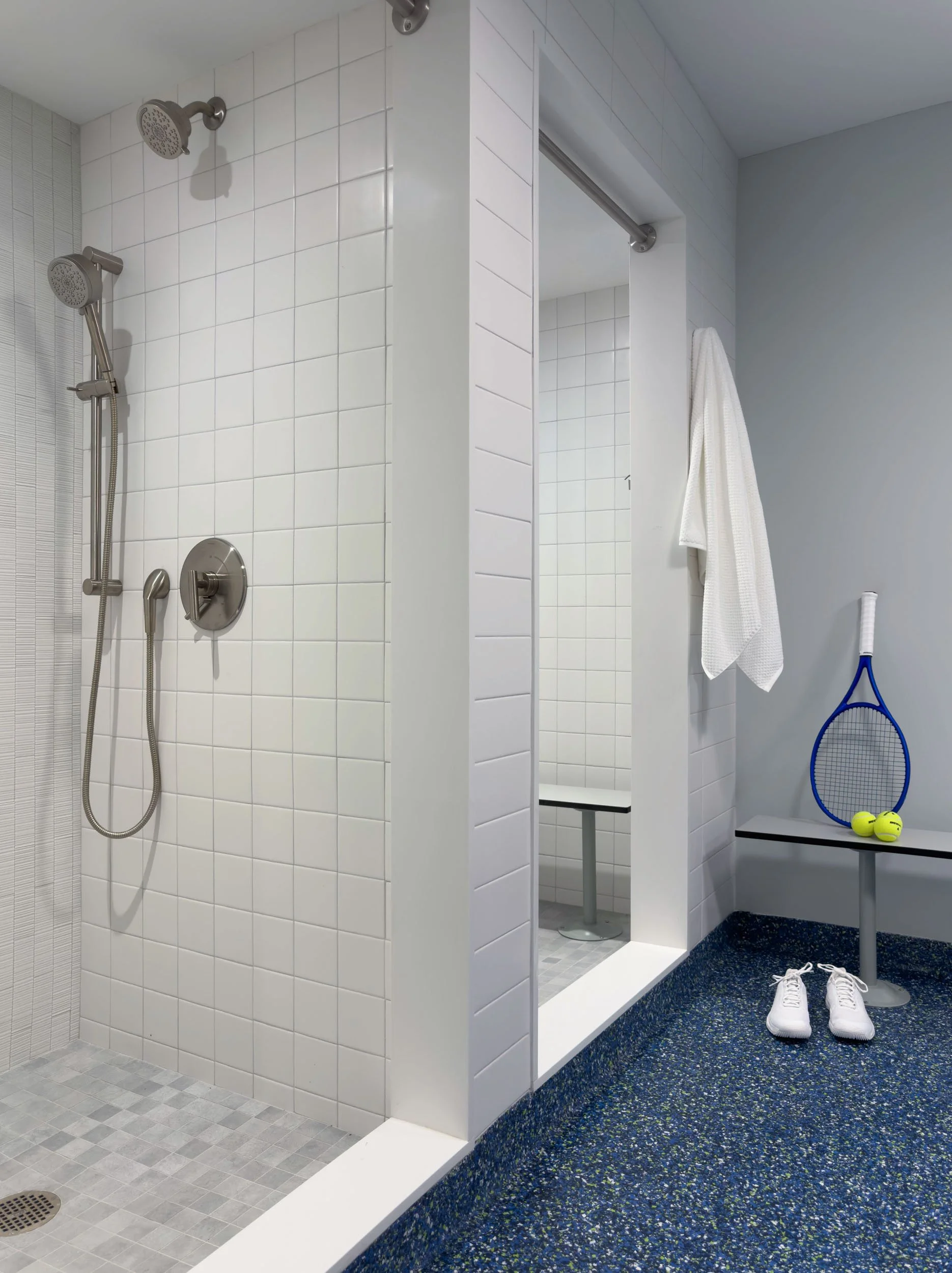 standard locker room shower with white square subway tile and brushed nickel shower fixtures