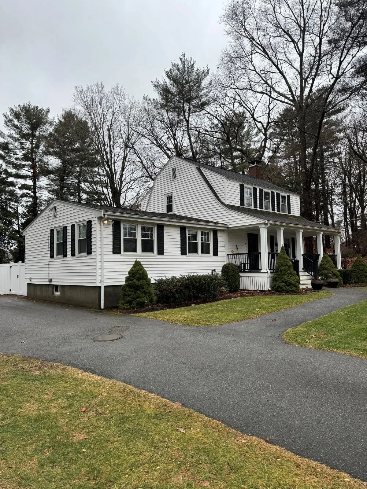 Existing front facade of a Dutch Colonial home in Greater Boston prior to second story addition showing original massing and entry before renovation by Tact and Grit Design Co.
