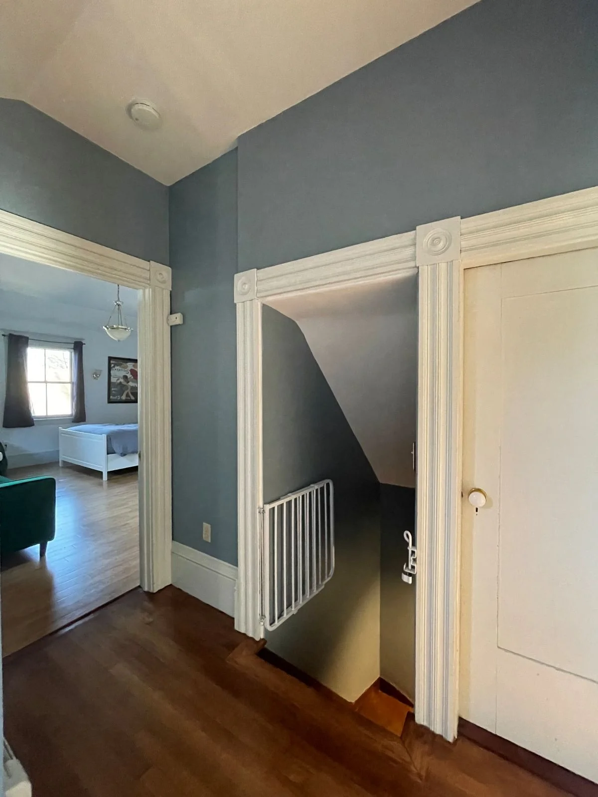 Existing staircase of an 1846 Victorian home in Newton MA prior to primary suite reconfiguration showing original second level hallway and stair to be removed