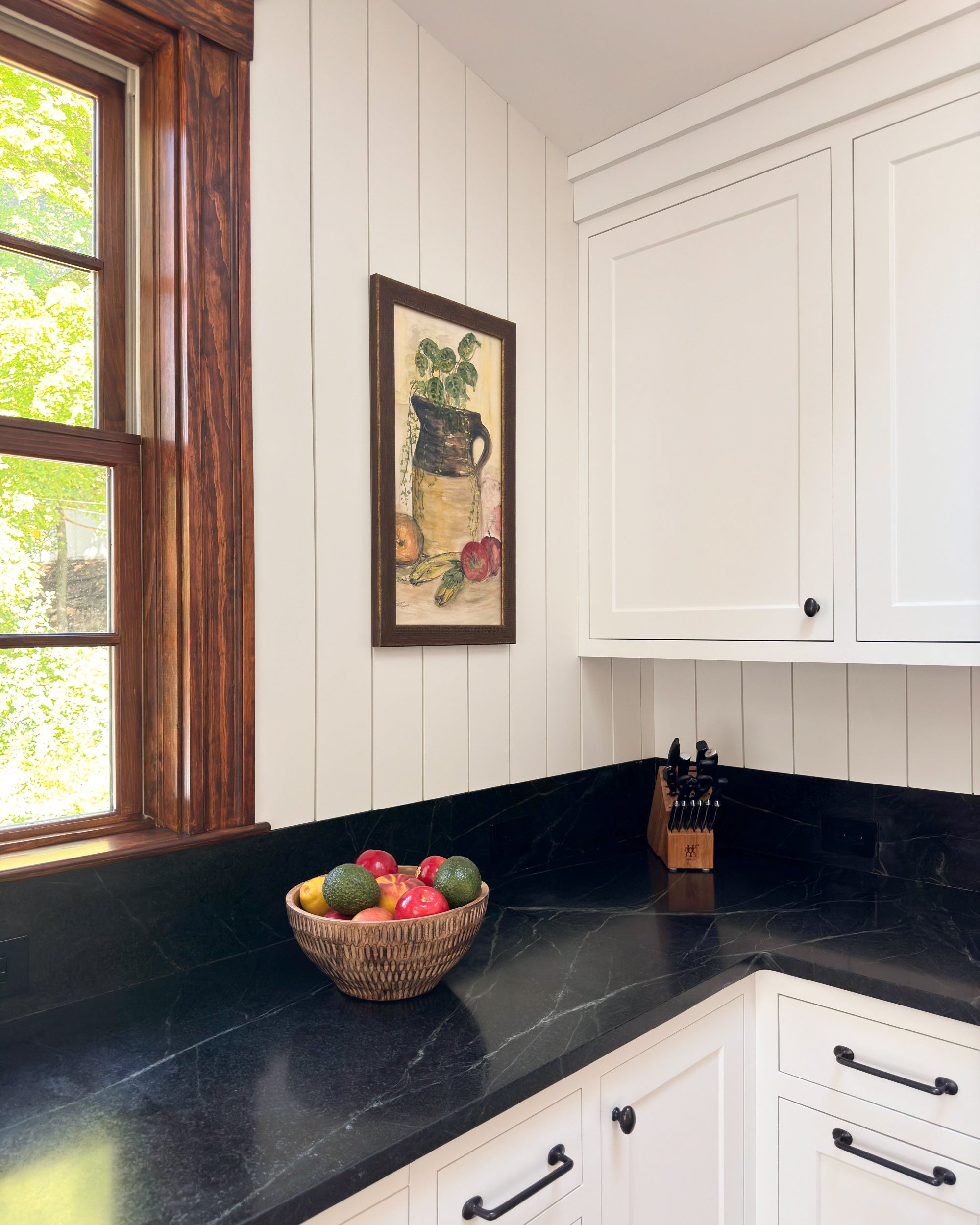 Soapstone countertop corner detail with  dark-stained wood window trim and vertical shiplap walls, Medford MA kitchen addition
