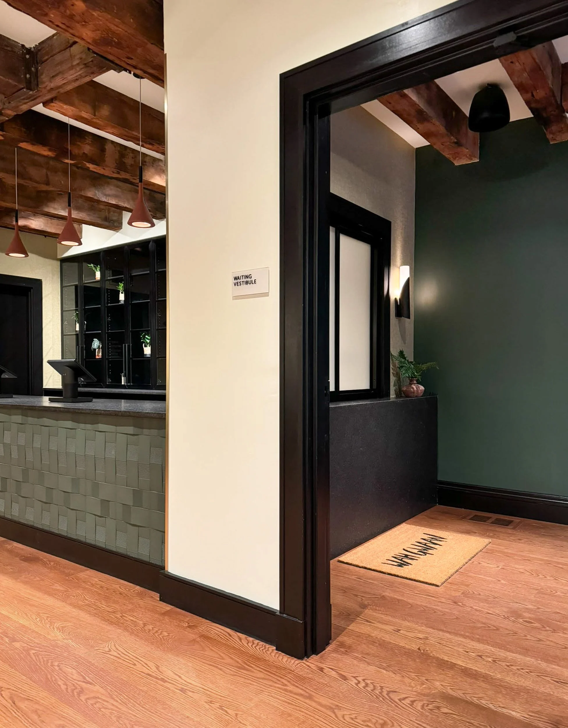 relationship between vestibule check in window and POS counter with display beyond under original heavy timber beams.