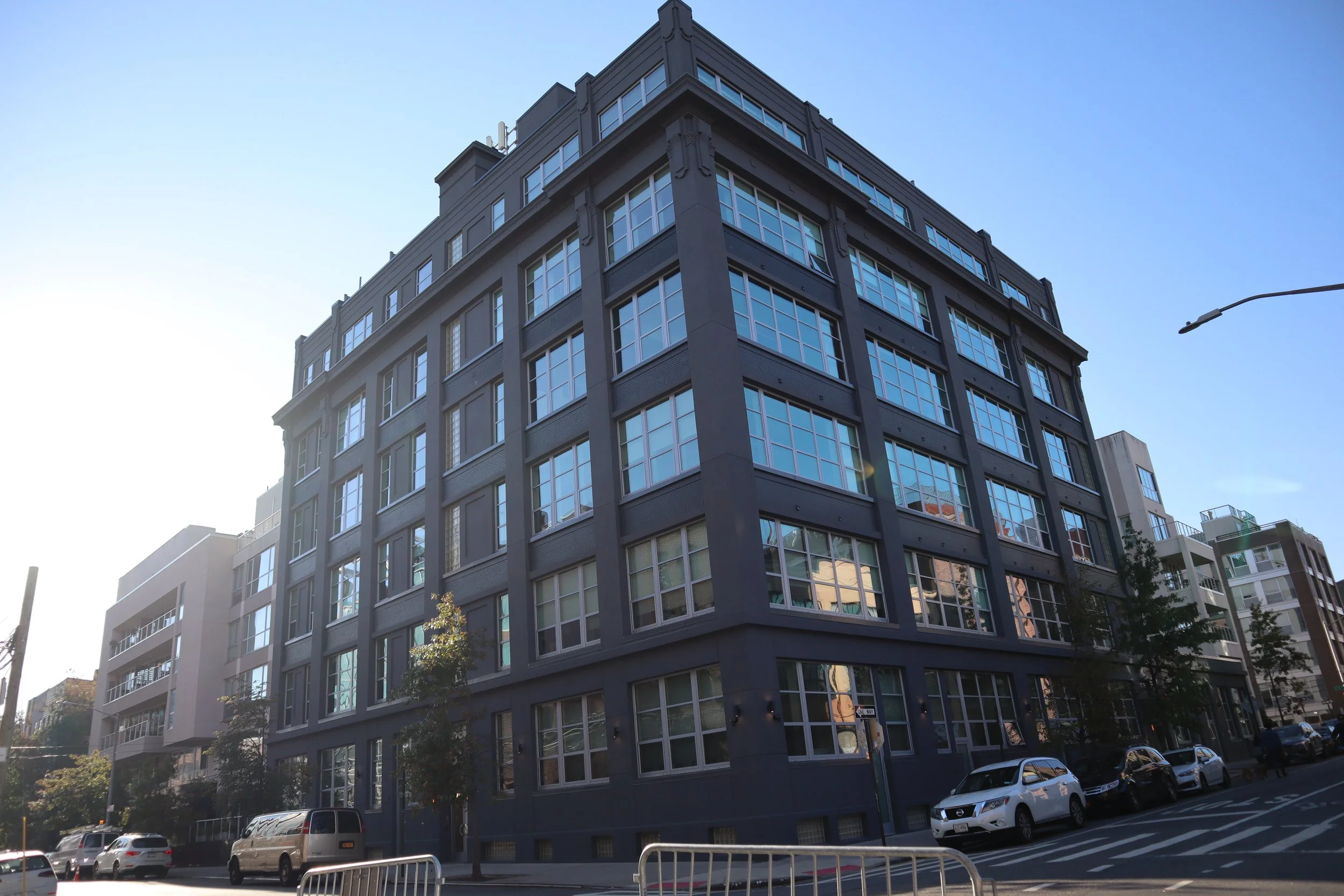 A multi-story modern building with large glass windows on a city street.