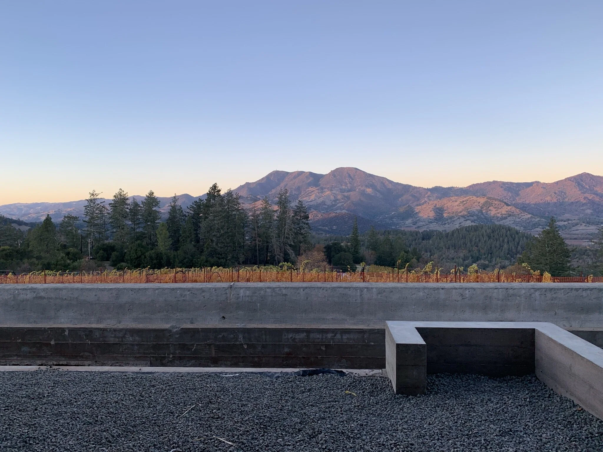 A view of the stone parapet with the vineyards and mountains in the background