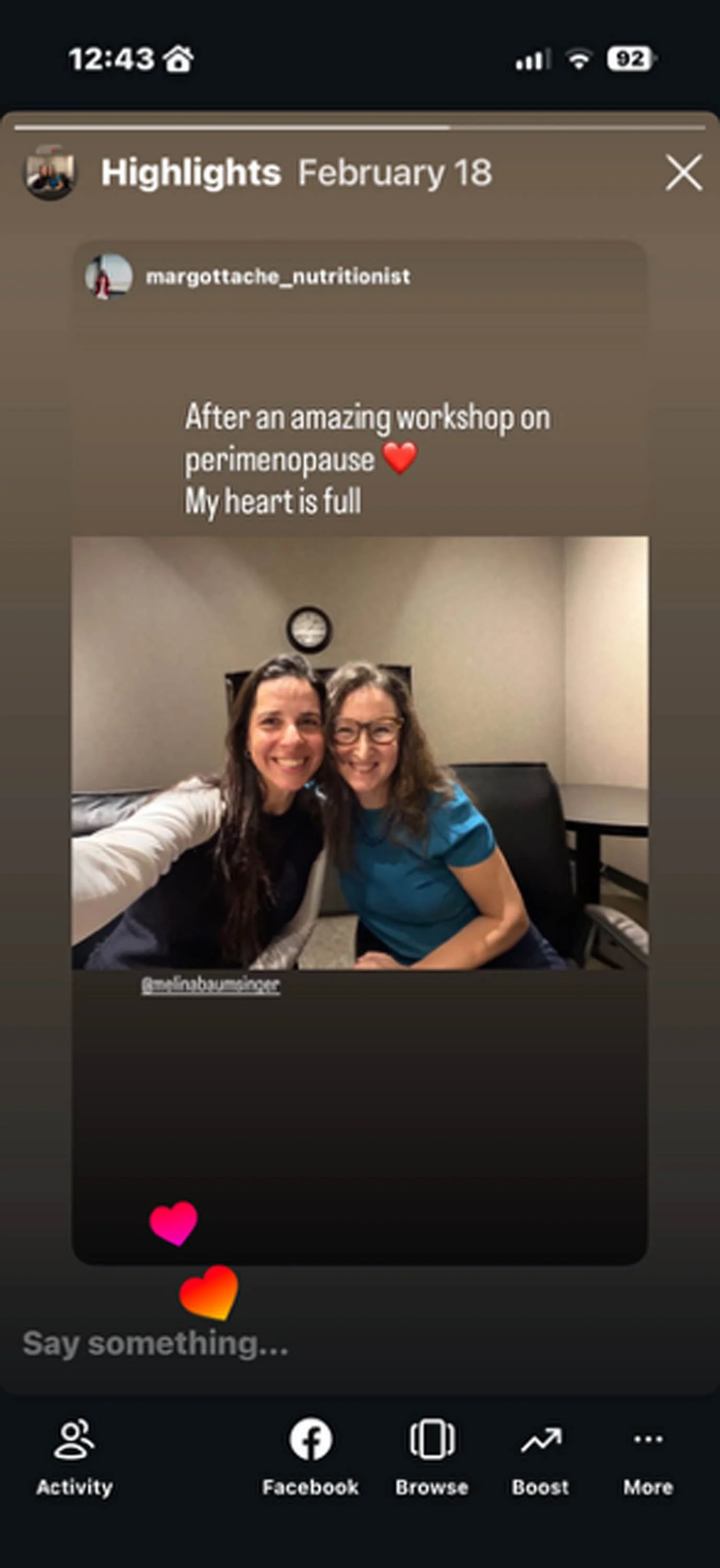 Two women sitting together in an office or conference room, smiling for a selfie. There is a clock on the wall behind them and a black leather chair is visible. The image is part of a social media story about a workshop on perimenopause.