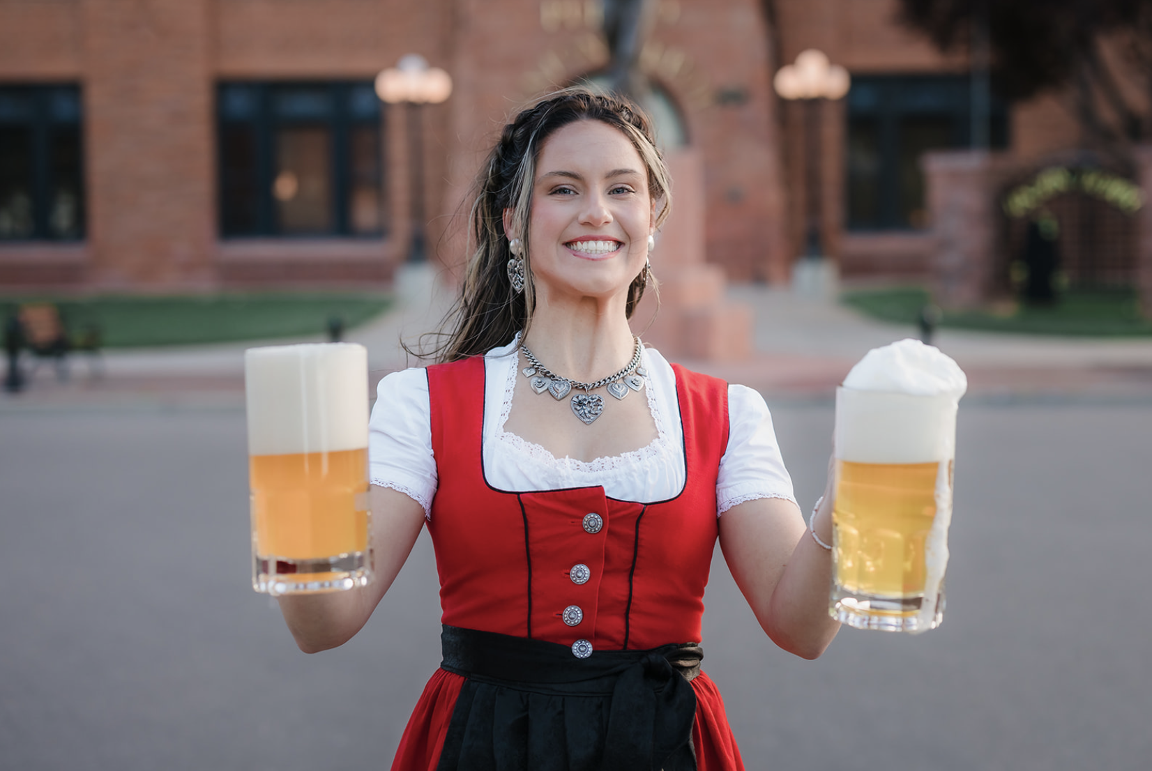Family of five with a dog enjoying a sunny day outdoors in a park with green trees.