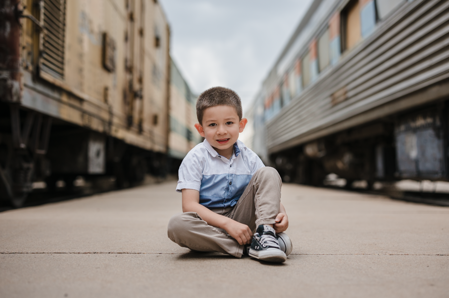 Black and white photo of a man and woman standing outdoors among trees, facing opposite directions with serious expressions, the woman in the foreground and the man slightly behind.