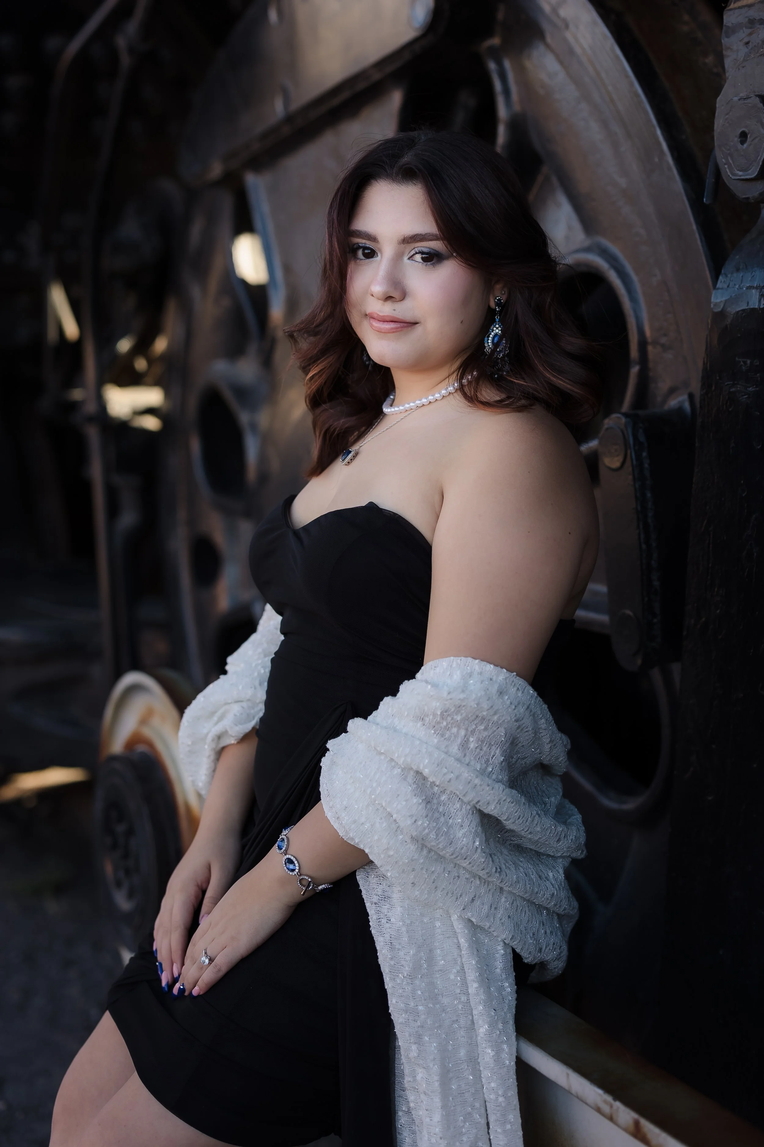 Family of five with a dog enjoying a sunny day outdoors in a park with green trees.