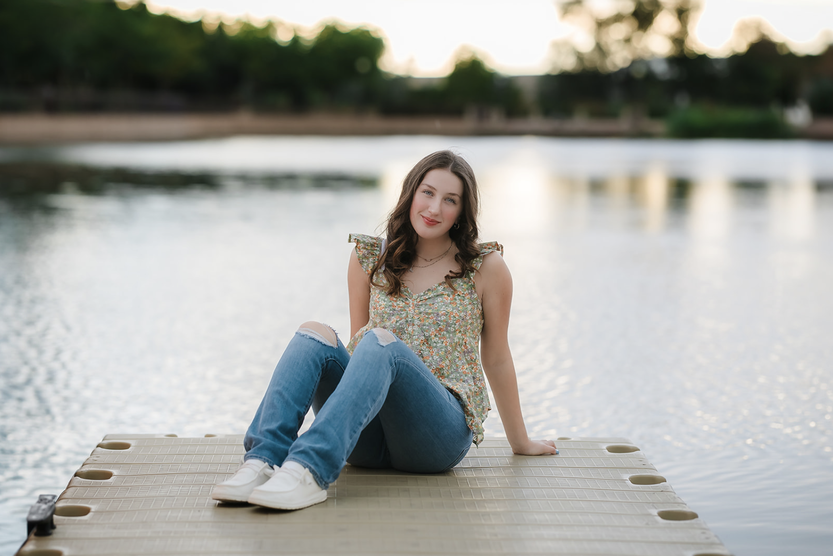 Family of five with a dog enjoying a sunny day outdoors in a park with green trees.