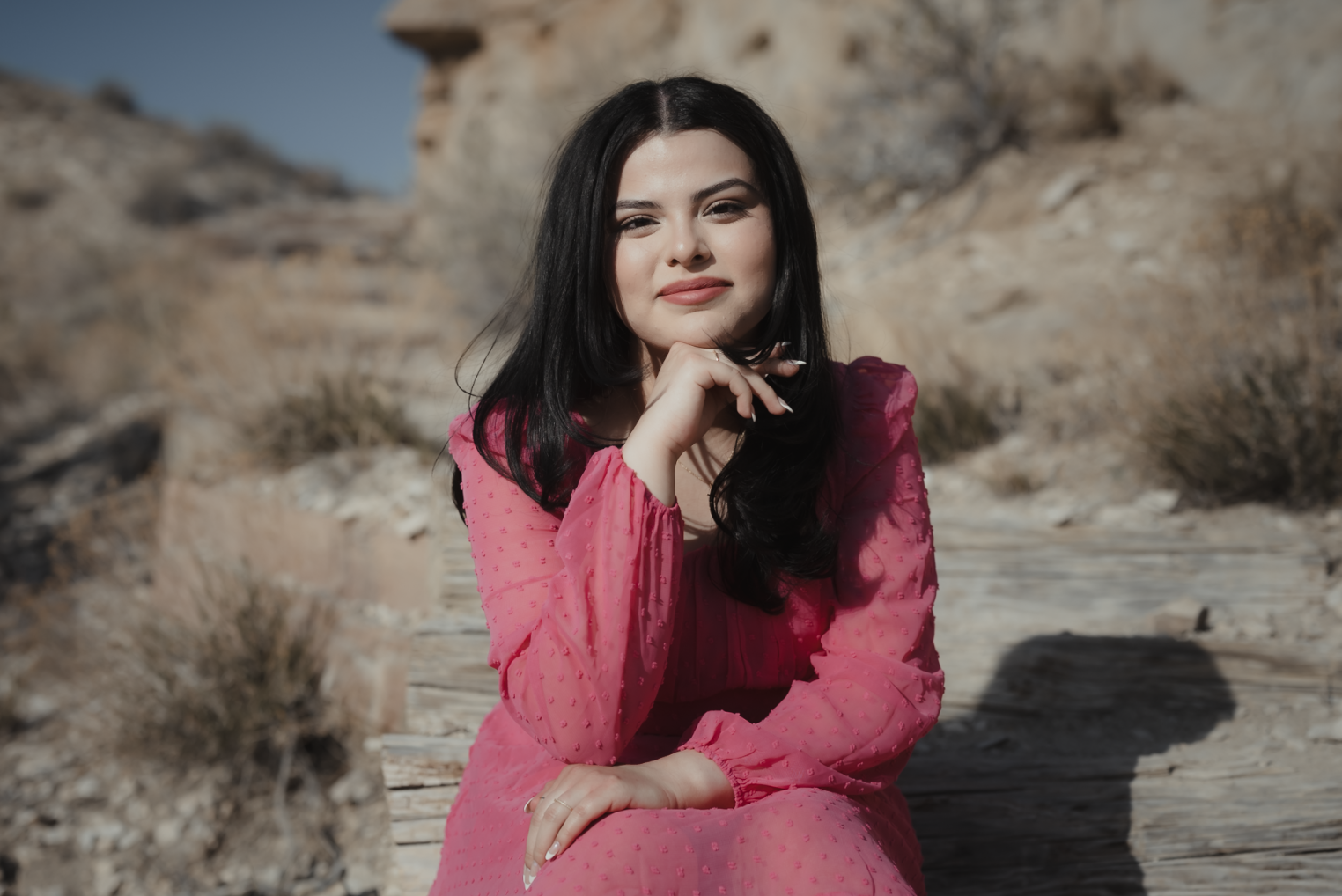 Family of five with a dog enjoying a sunny day outdoors in a park with green trees.