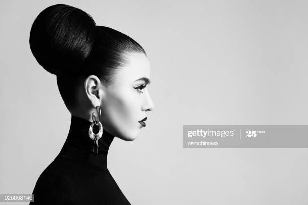 Retro style black and white fashion portrait of elegant female model with hair bun hairstyle and eyeliner makeup