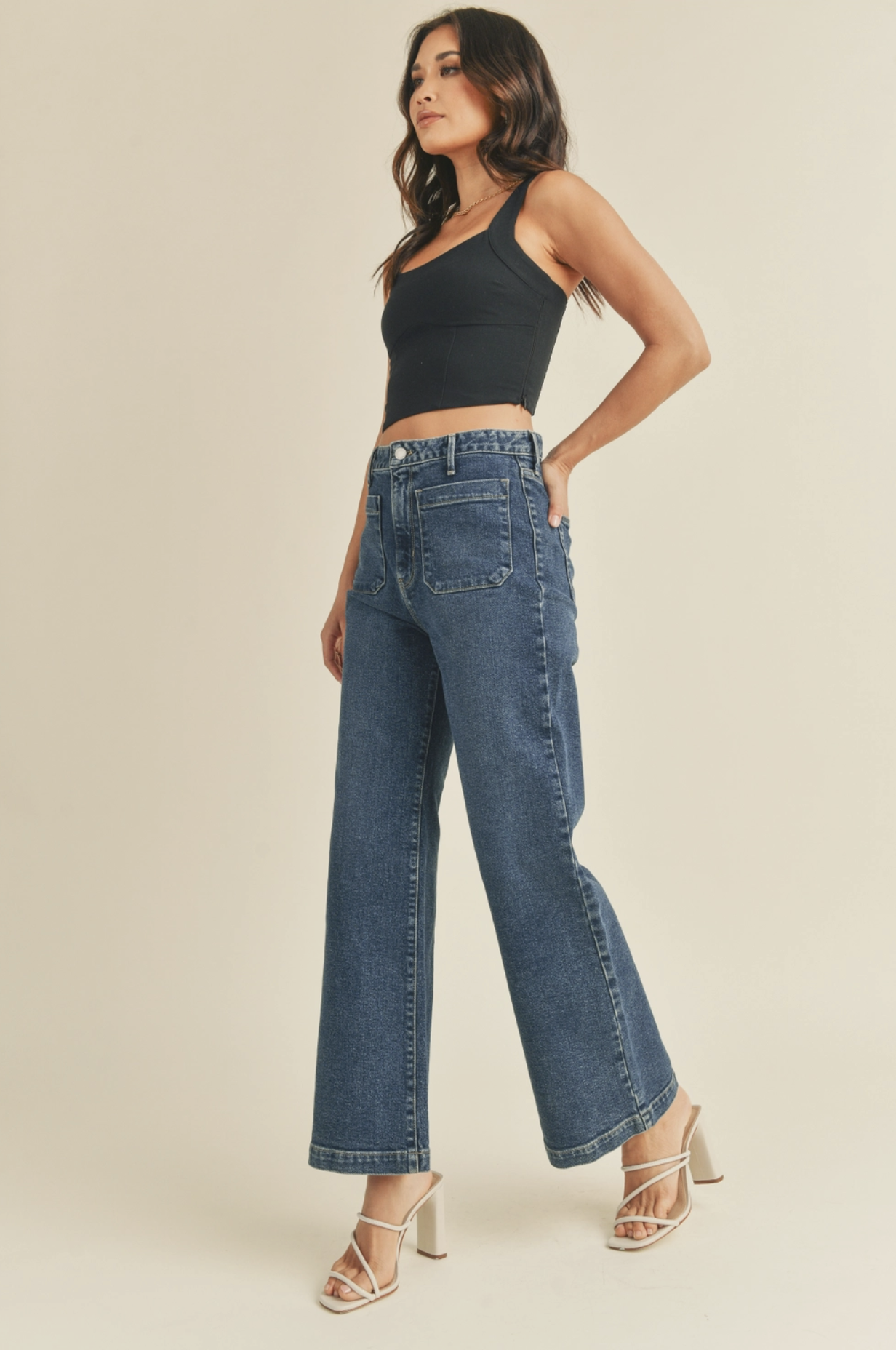 Model wearing the patch pocket jeans with a black tank top side view