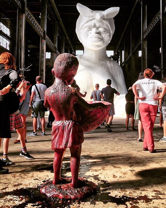A Subtlety aka the Marvelous Sugar Baby by Kara Walker // @kara_walker_official Brooklyn, NY 2014. A site-specific monument to the the unpaid and the overworked. A caged woman sculpted from blocks of unrefined sugar sits in a sphinx-like pose with he