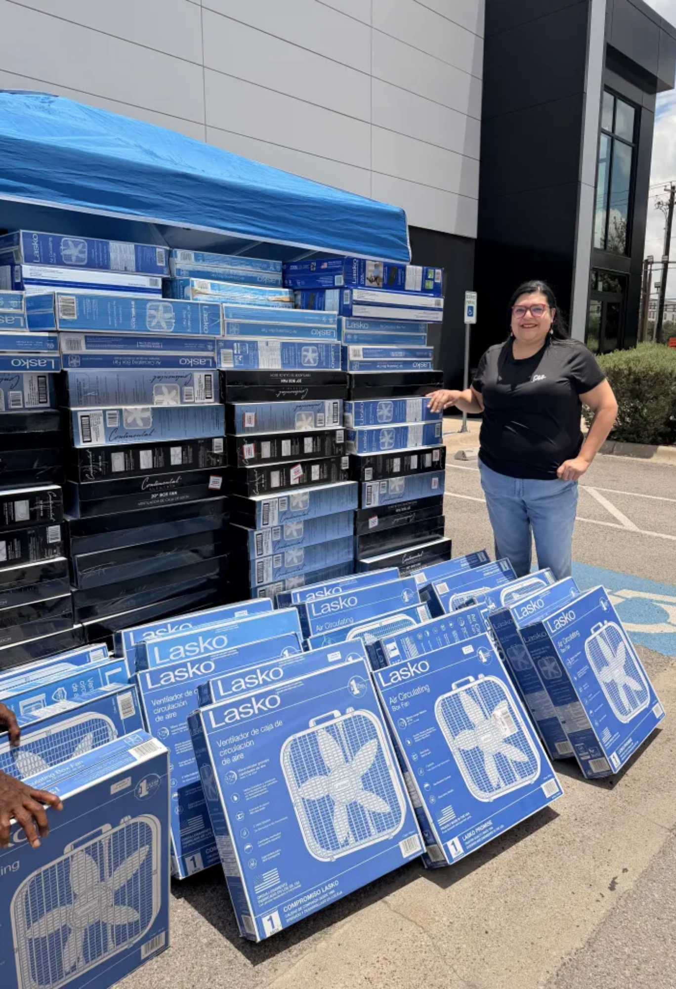 Stacks of box fans with a person standing by them