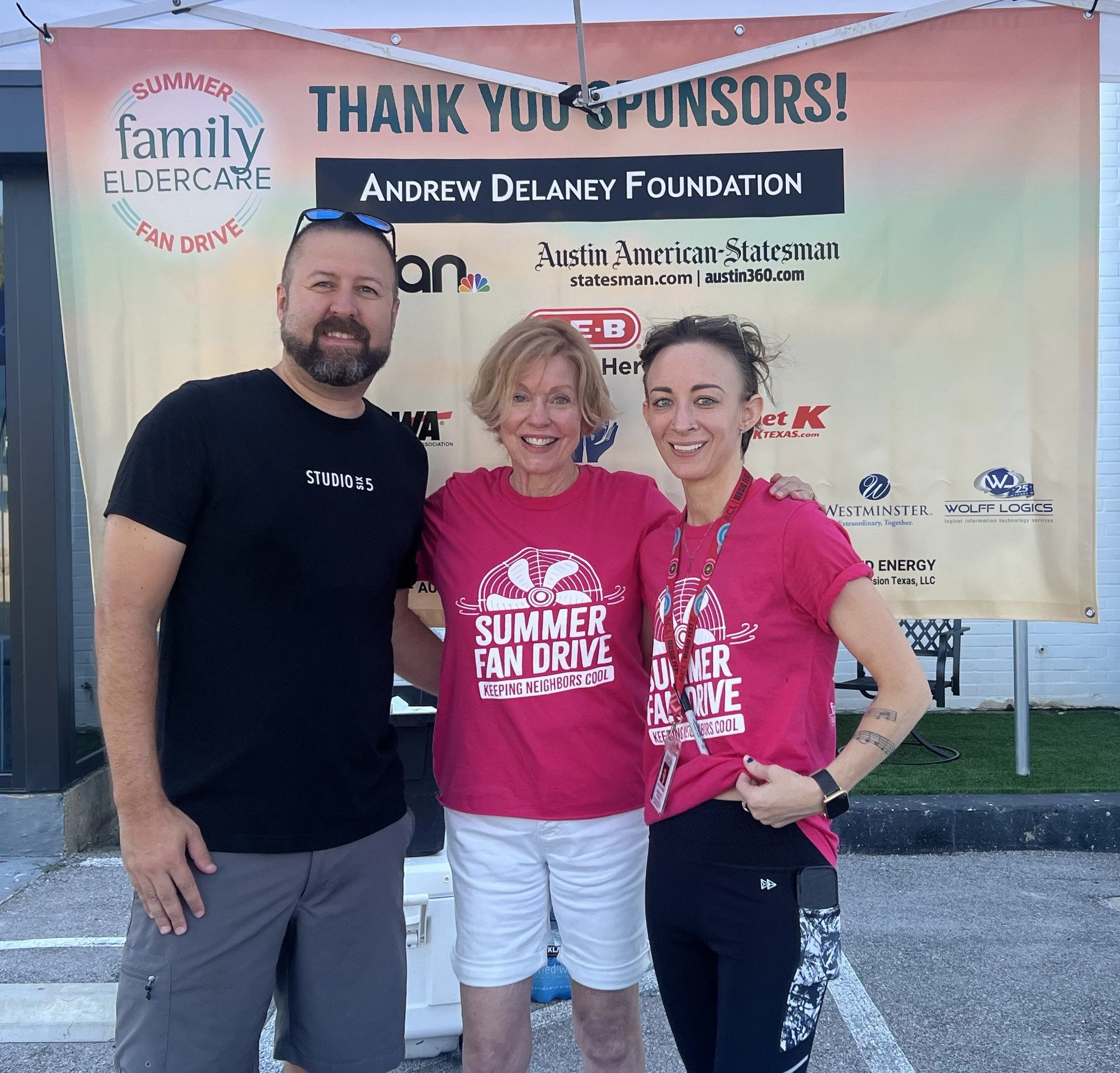 3 people standing in front of a thank you sponsors sign