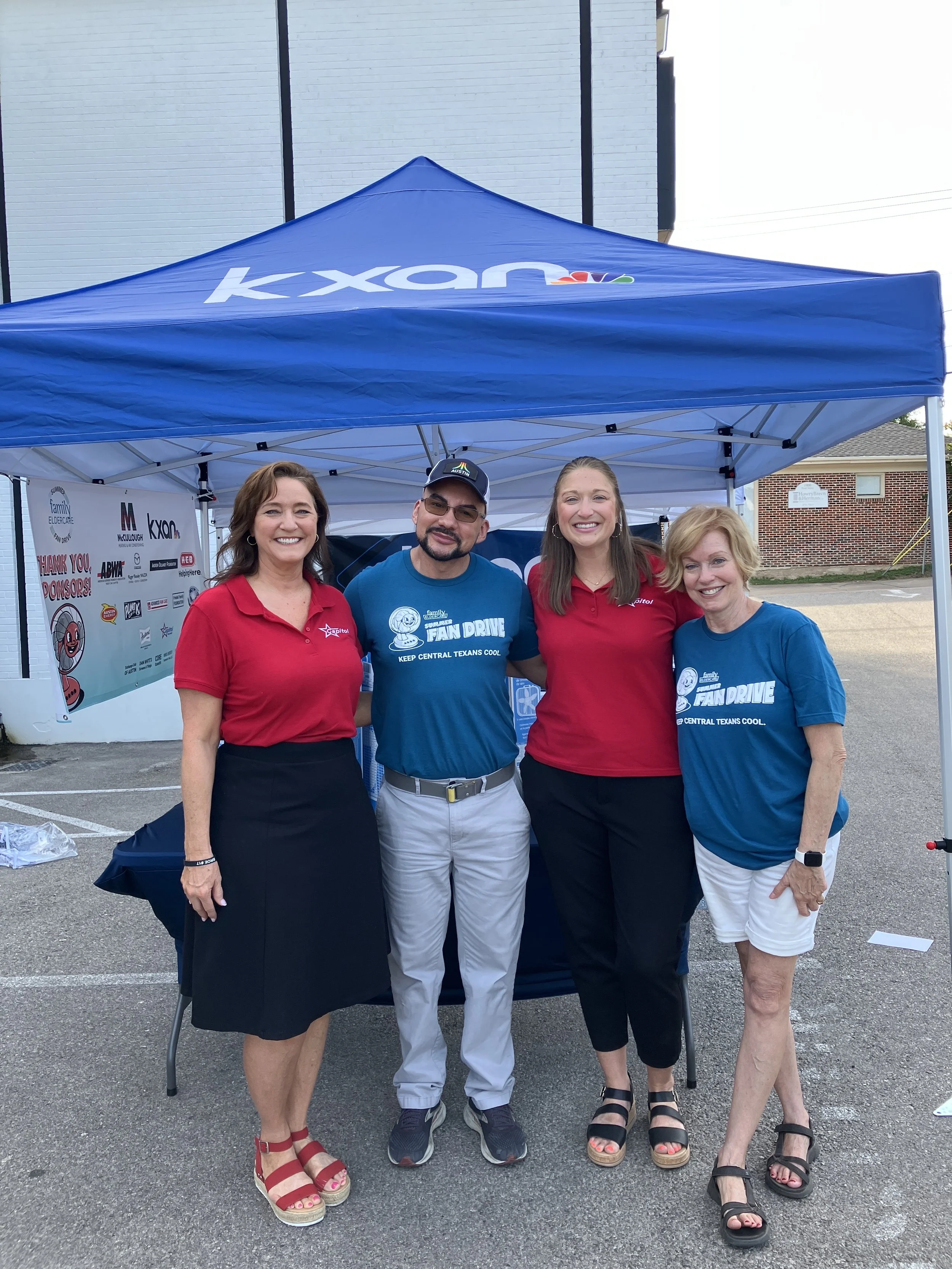 4 people standing under a tent