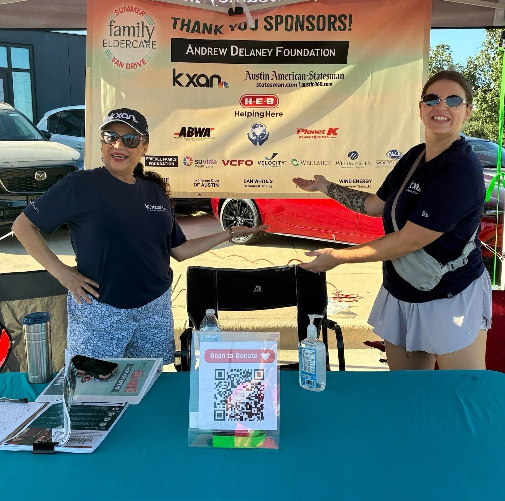 2 people standing in front of a thank you sponsors sign