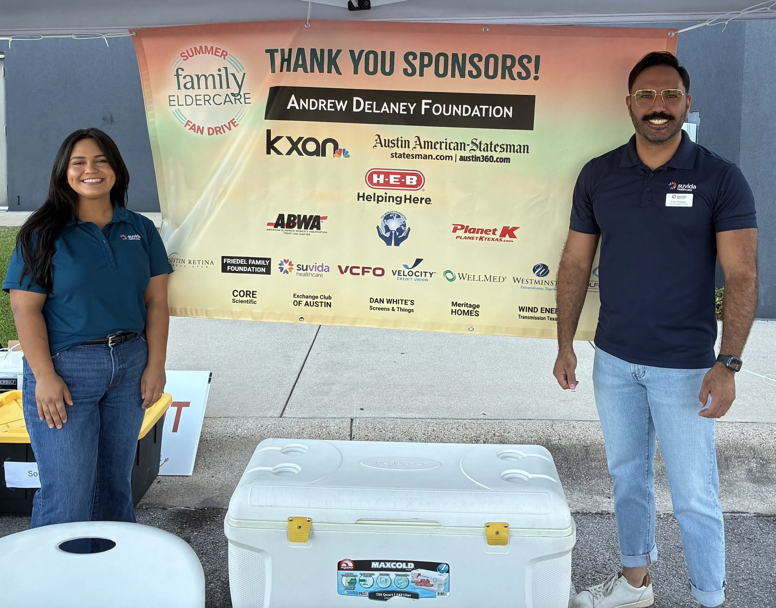 2 people standing in front of a thank you sponsors sign
