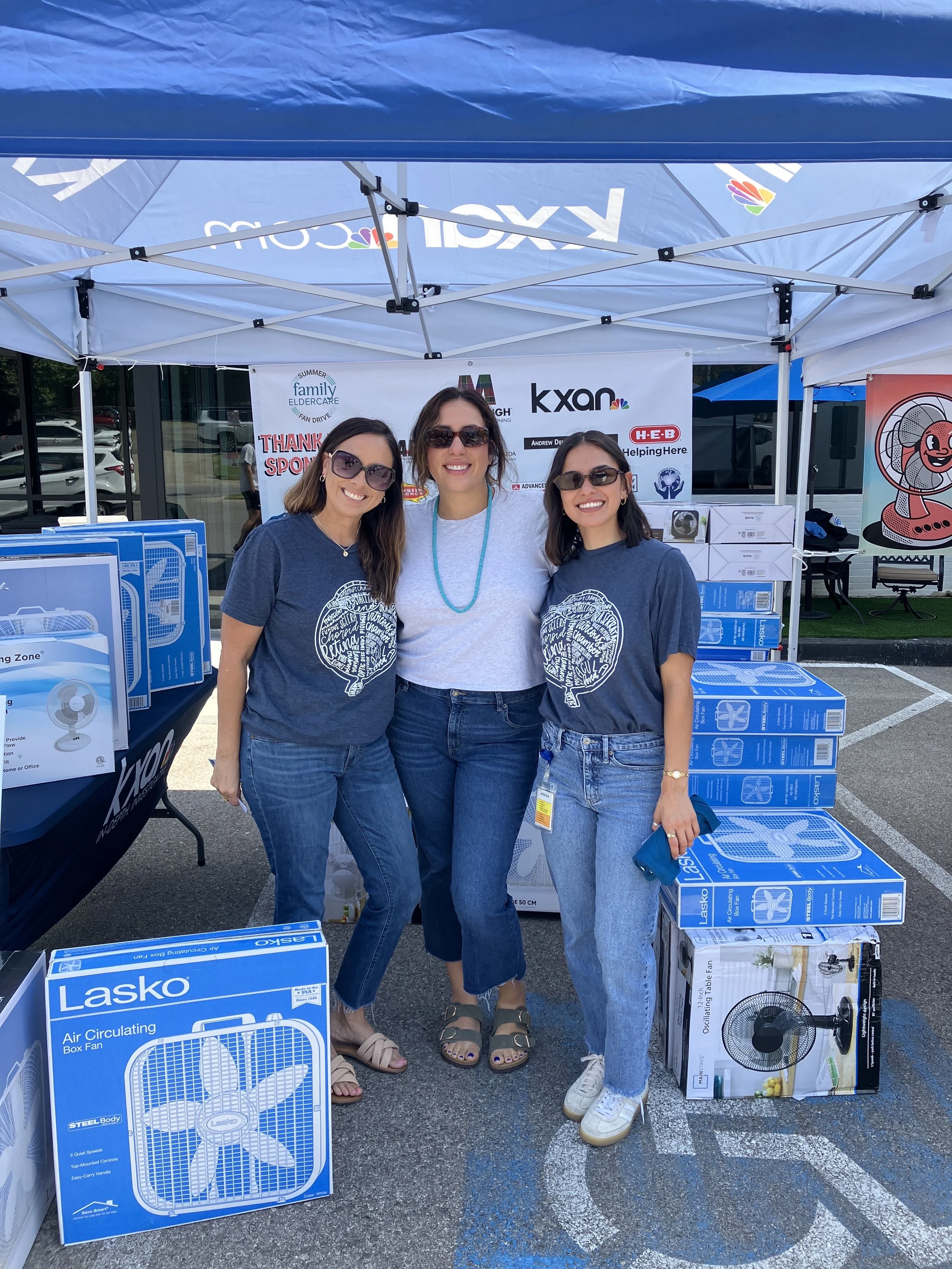 3 people standing under a tent