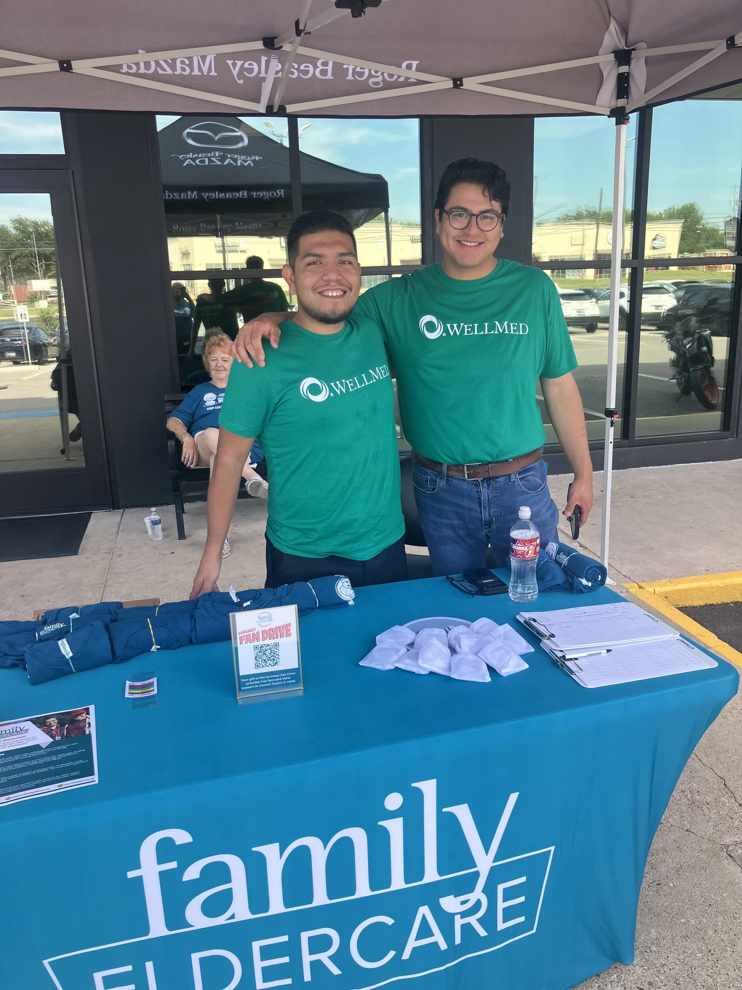 2 people standing under a tent