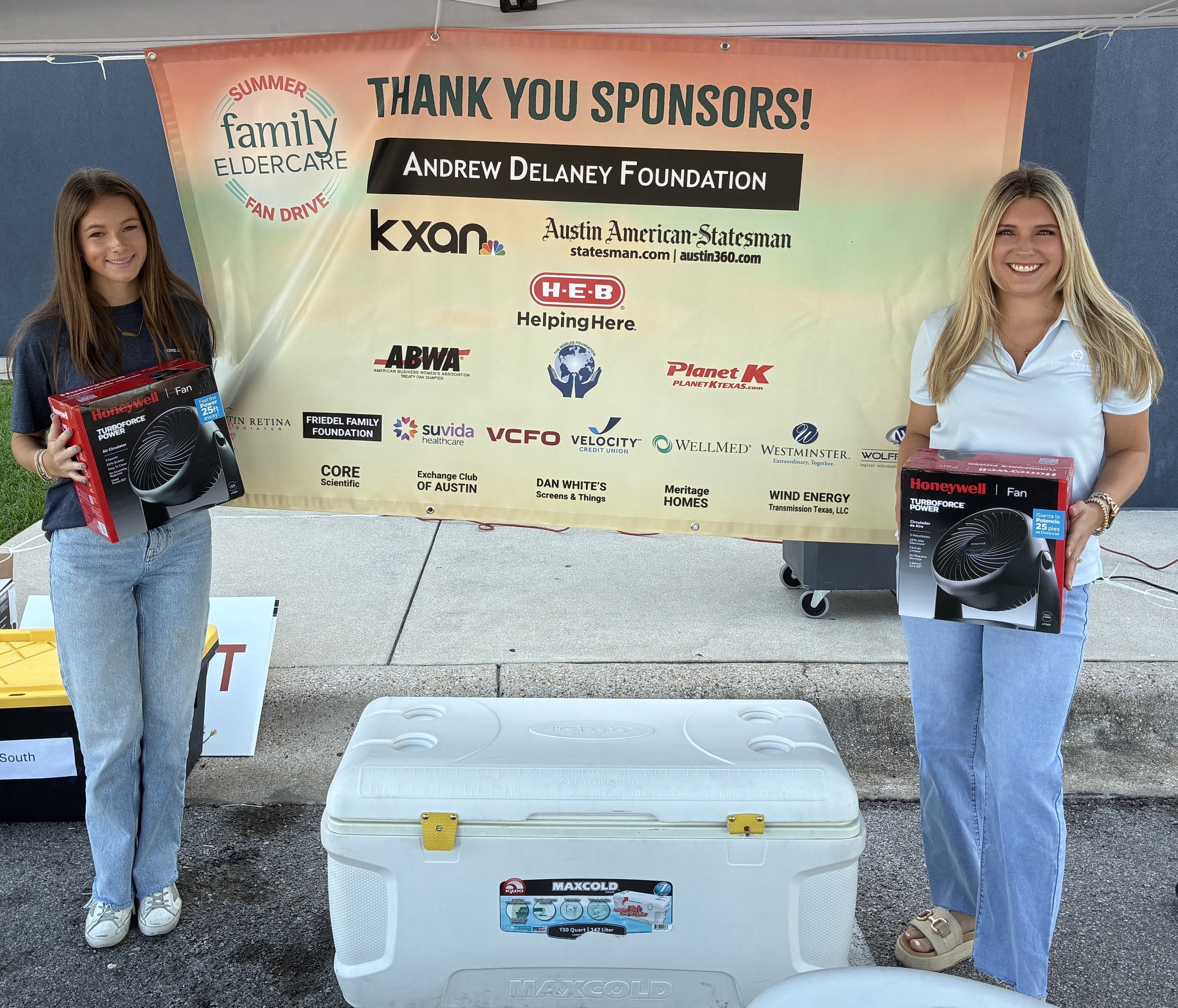 2 people standing by Thank you Sponsors sign