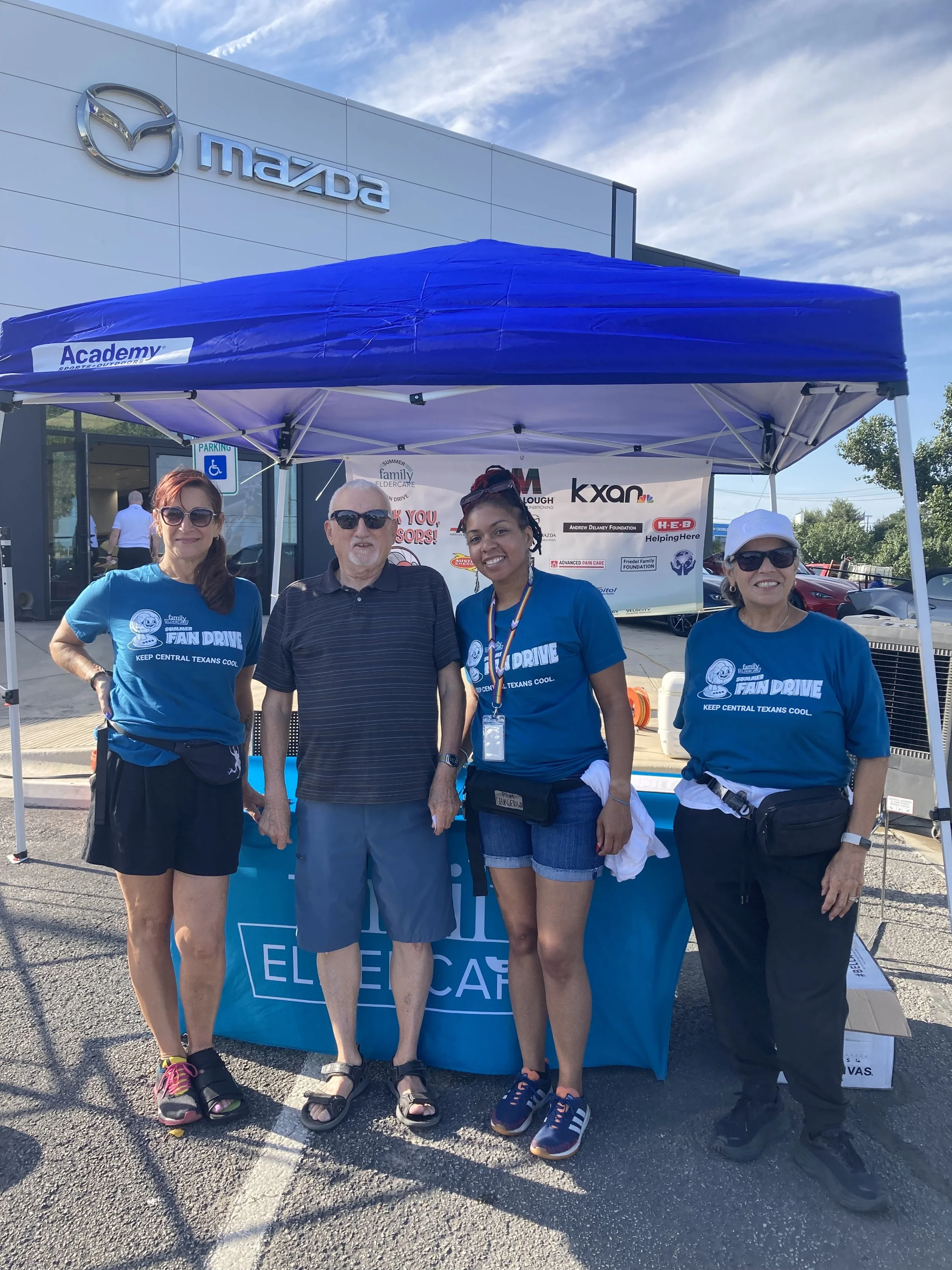 4 people standing under a tent