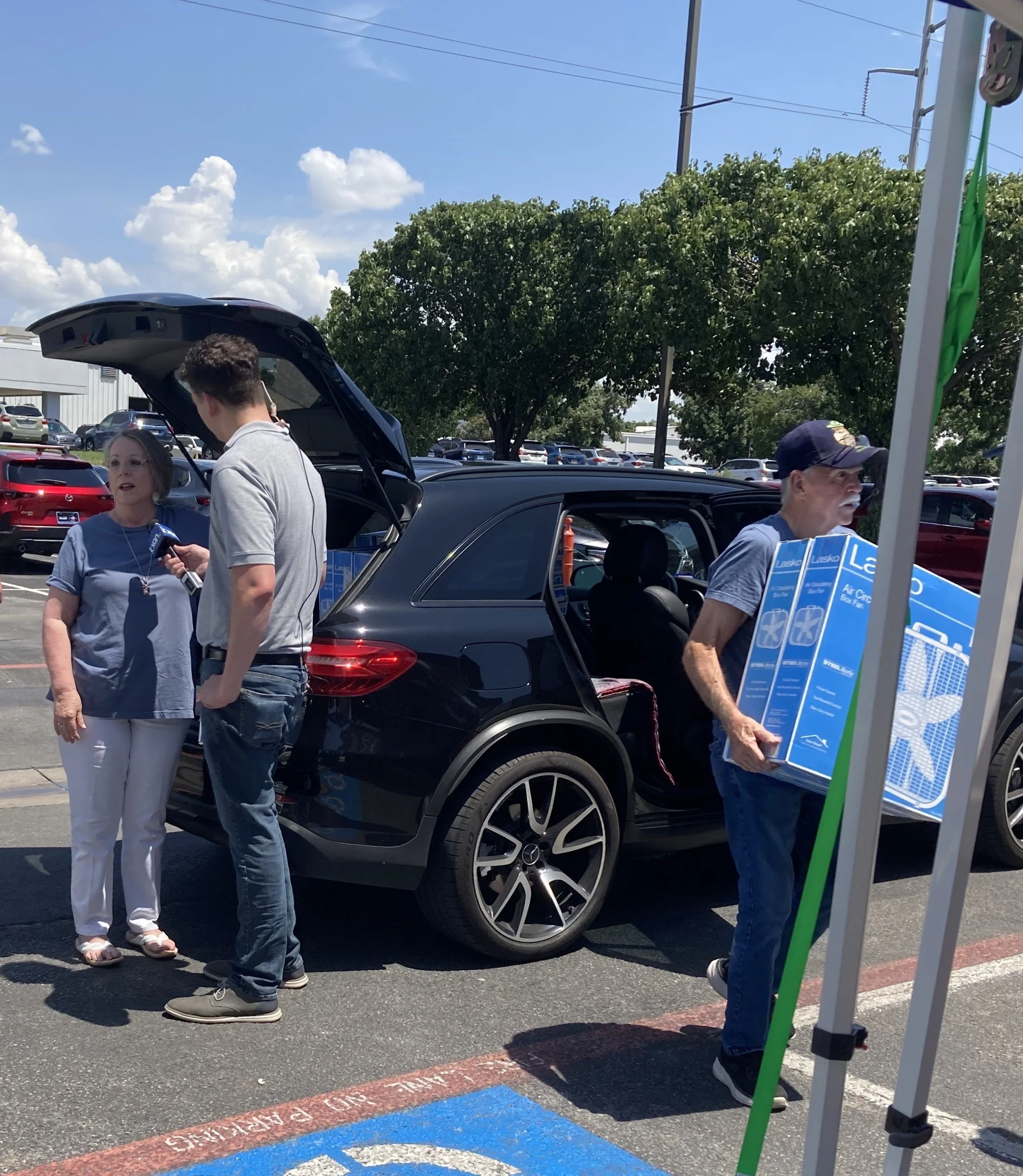 People unloading fans from a car