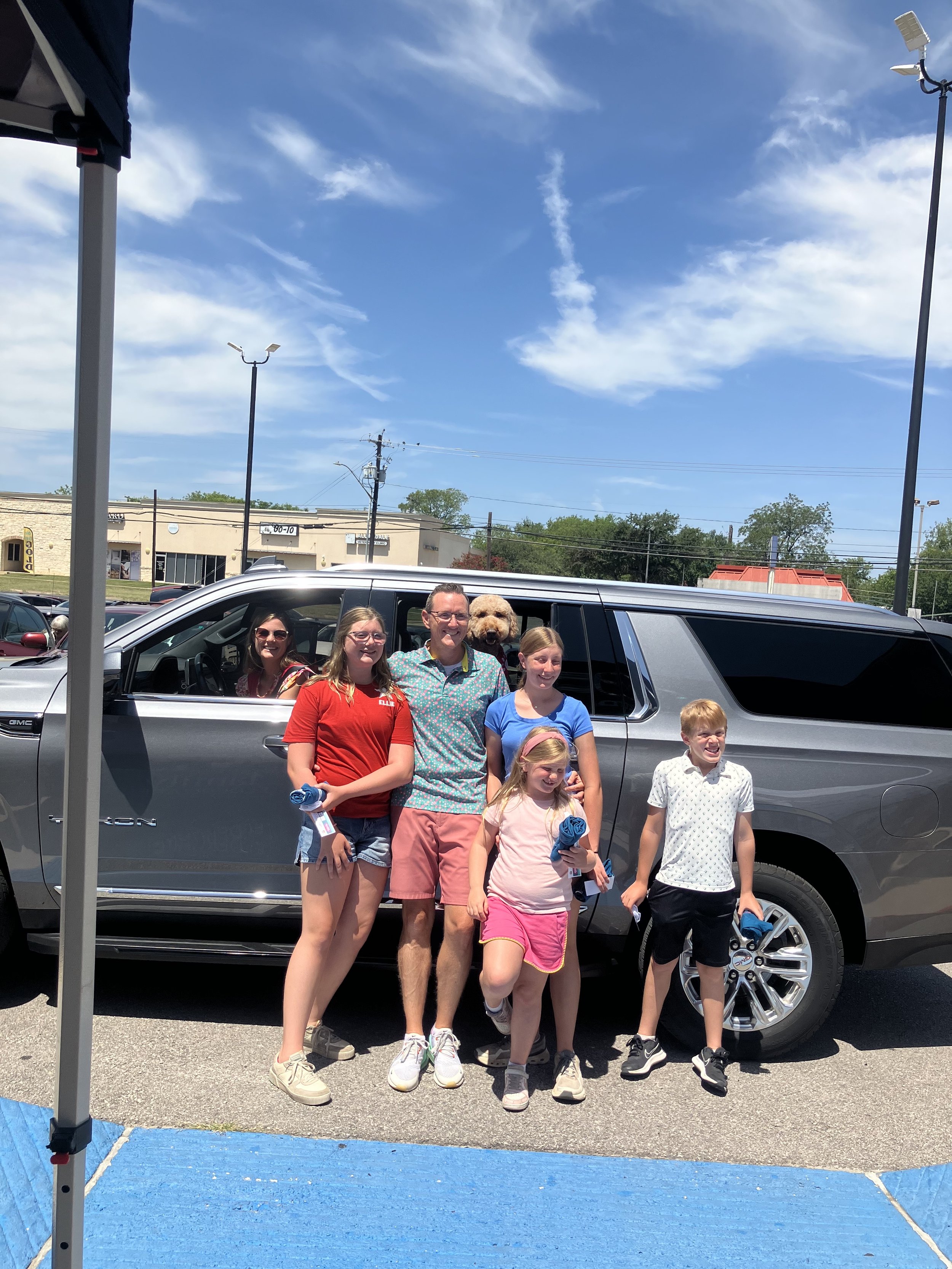A family in front of a car