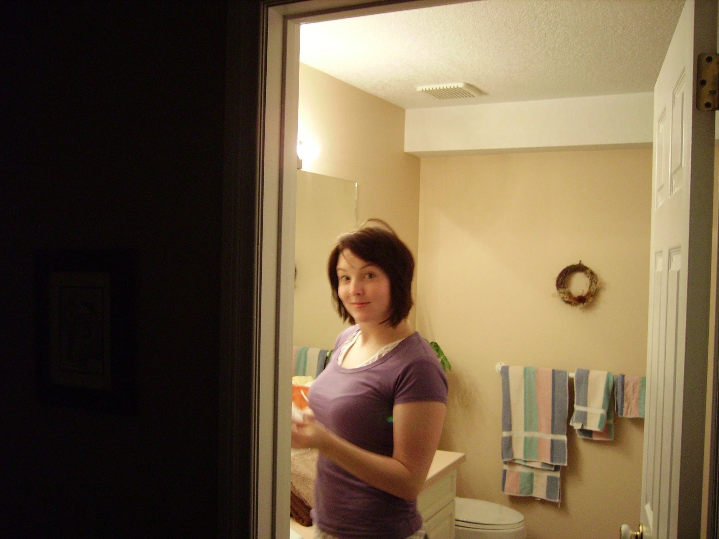 Sarah caught off guard in a bathroom brushing her teeth