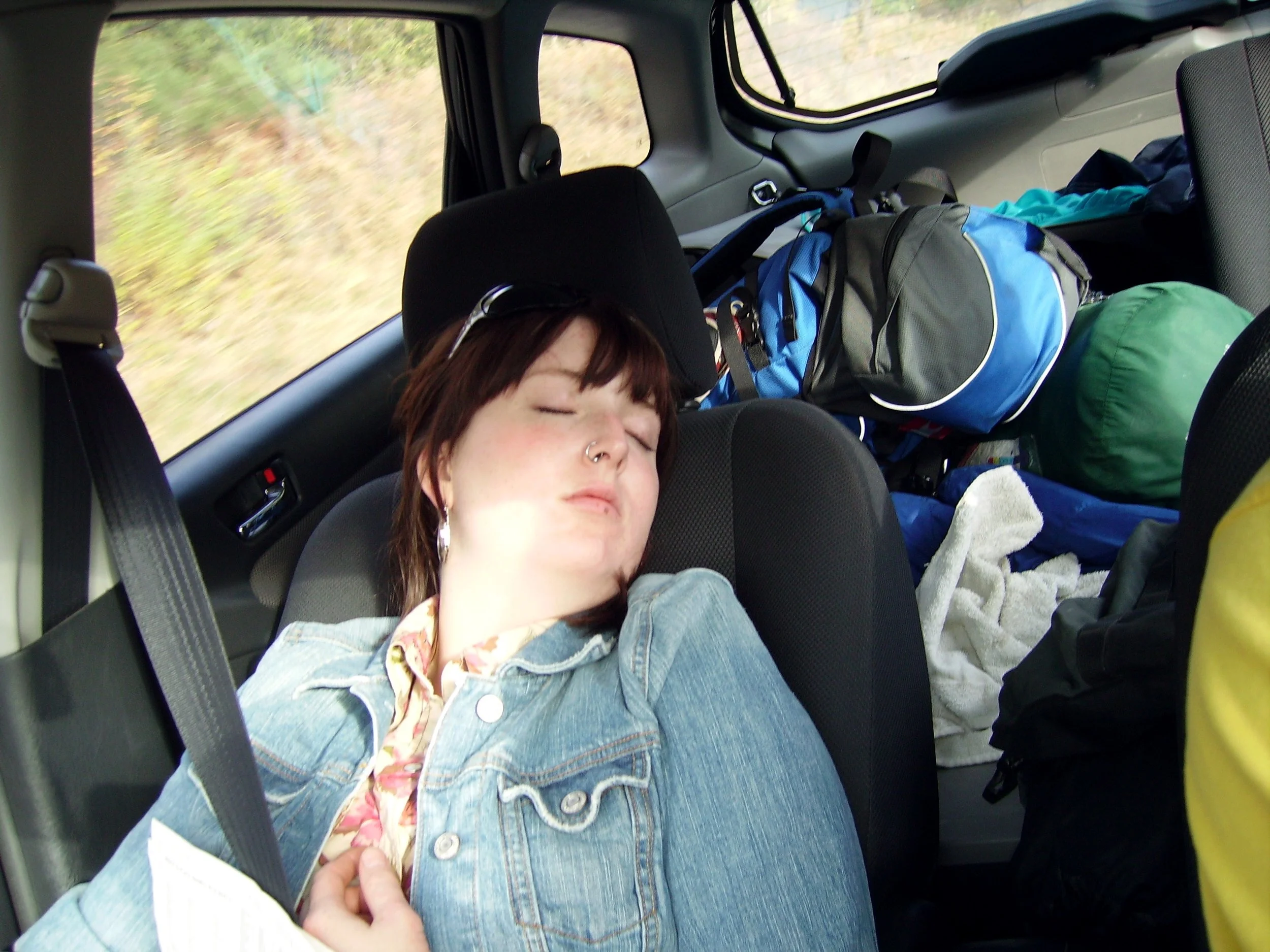 Sarah lying asleep in the passenger seat of a car