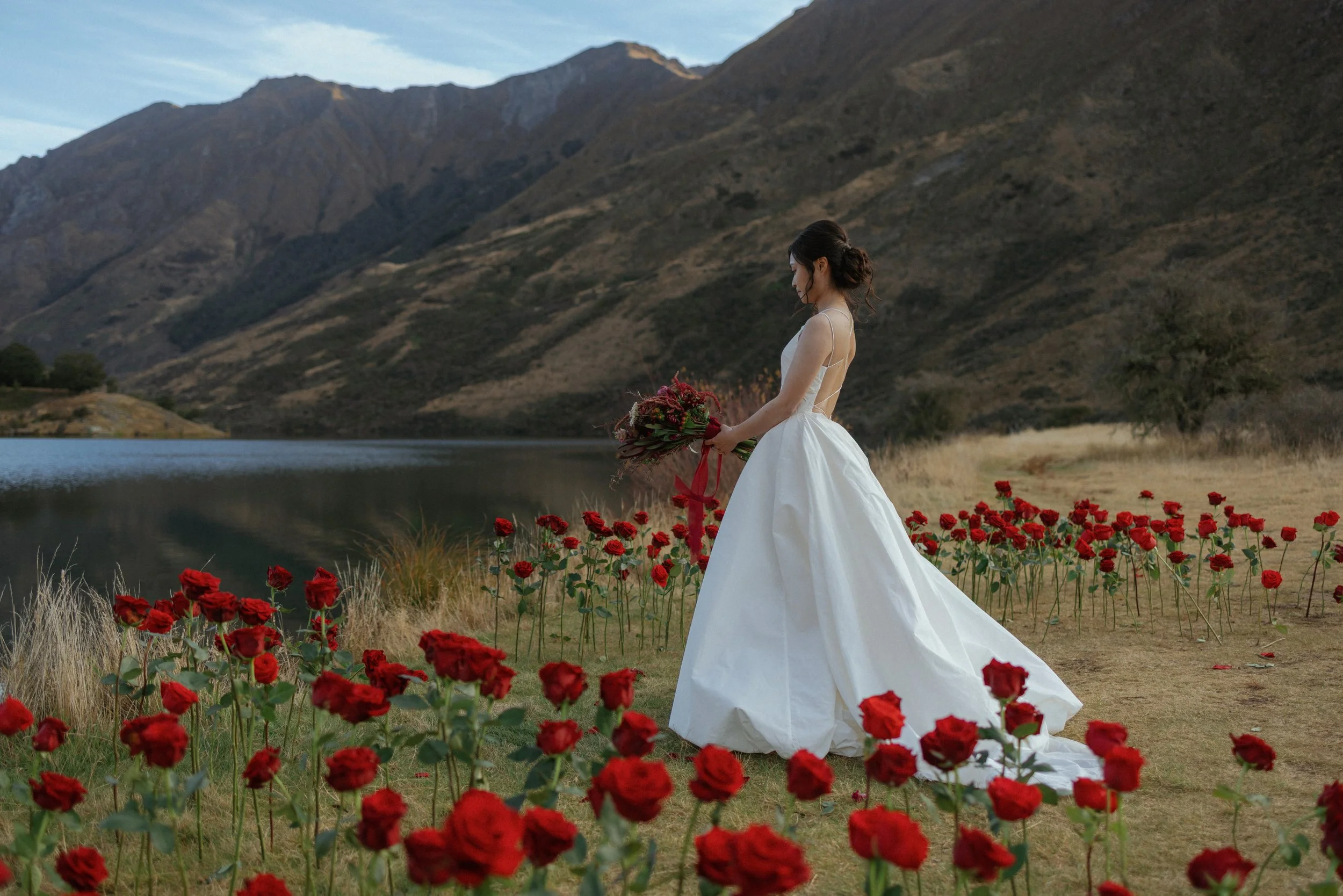 A bride taking location photos at Moke Lake after the ceremony