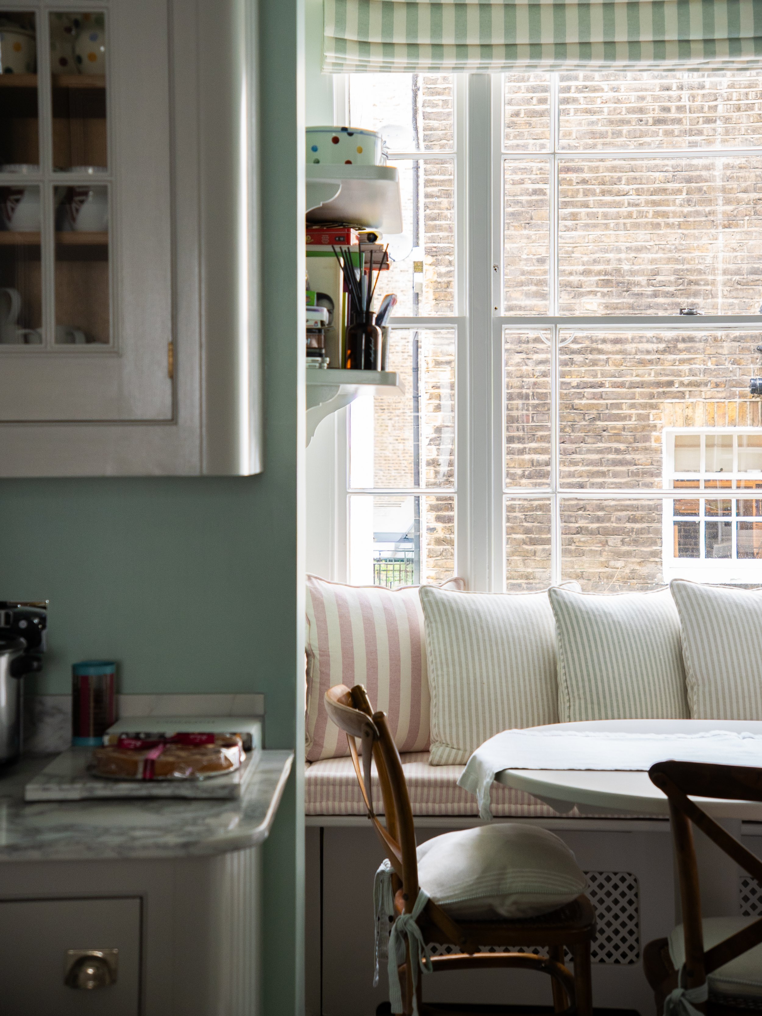 Kitchen banquette area with linen cushions in a london townhouse kitchen and dining room.