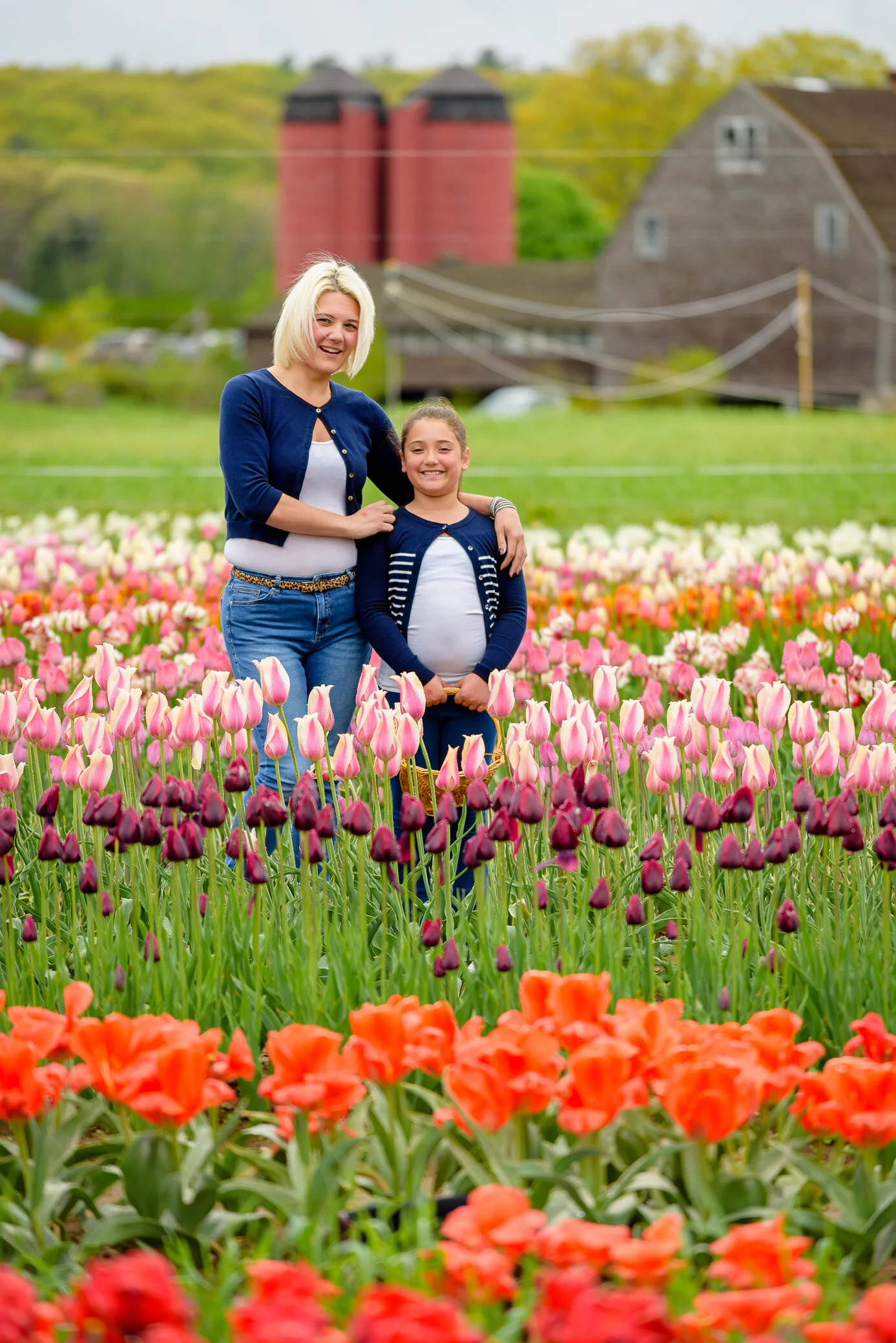 Mother and daughter standing in a field of tulips